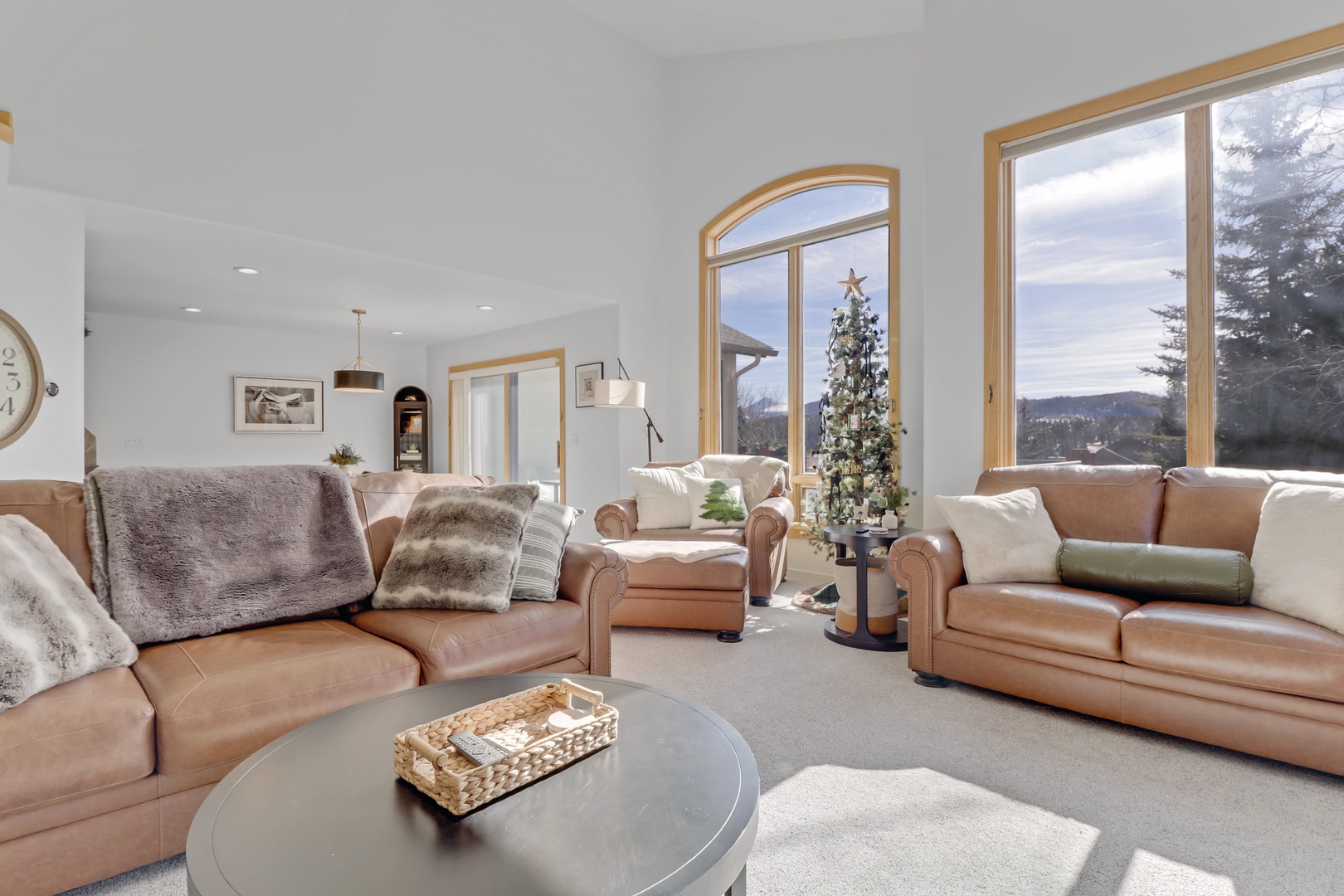 Sink into plush leather sofas where panoramic mountain views and warm natural light create your perfect winter retreat sanctuary.