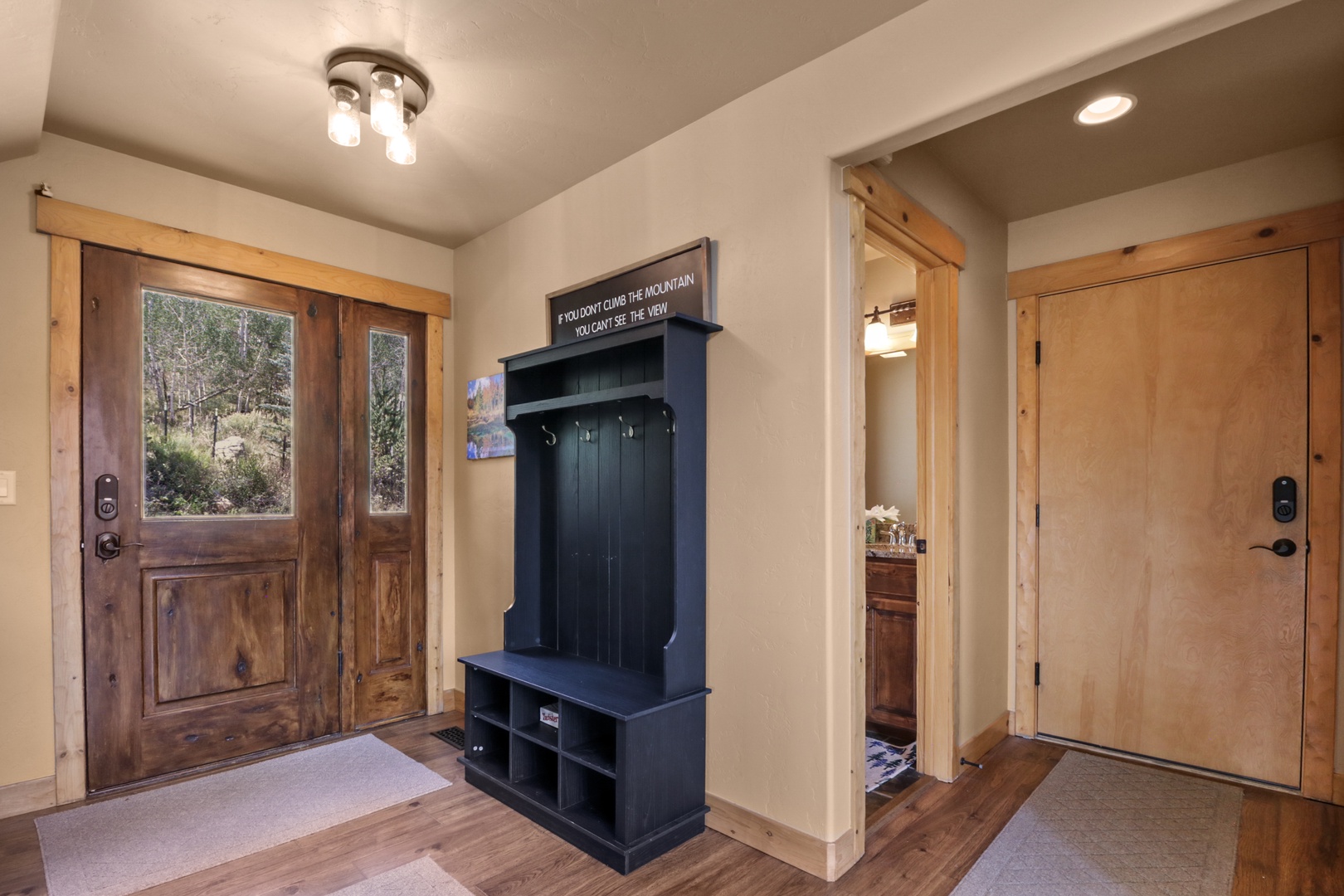 Step into your mountain getaway and leave your gear at the built-in entryway station—hooks and cubbies keep everything organized while you unwind in natural wood warmth.