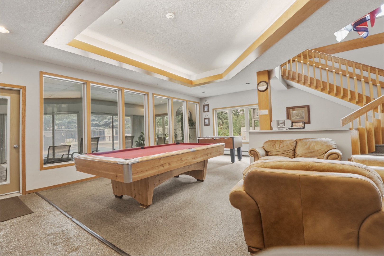 Challenge your travel companions to a friendly game in your spacious recreation room, where vaulted ceilings and abundant natural light create an inviting atmosphere for fun and relaxation.