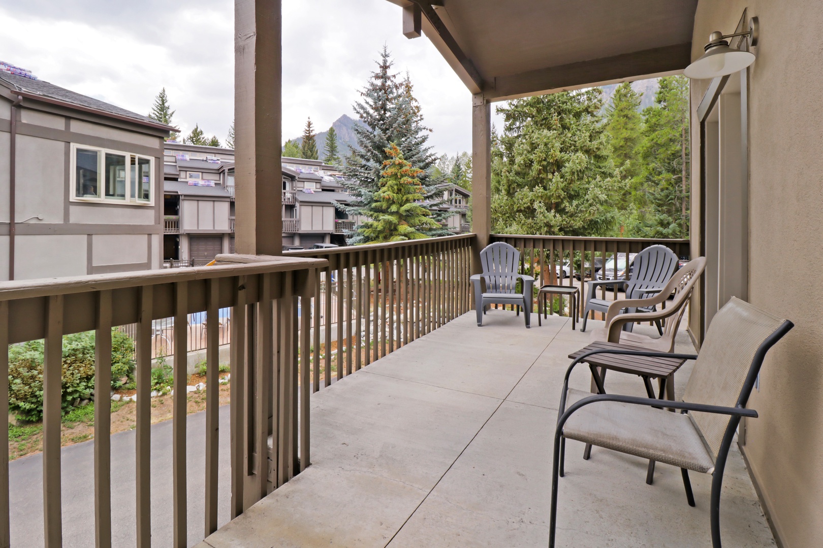 Step out onto your private covered balcony and sink into a comfy chair. The fresh mountain air surrounds you, while scenic peaks frame the horizon beyond the trees—your perfect spot to unwind any time of day.