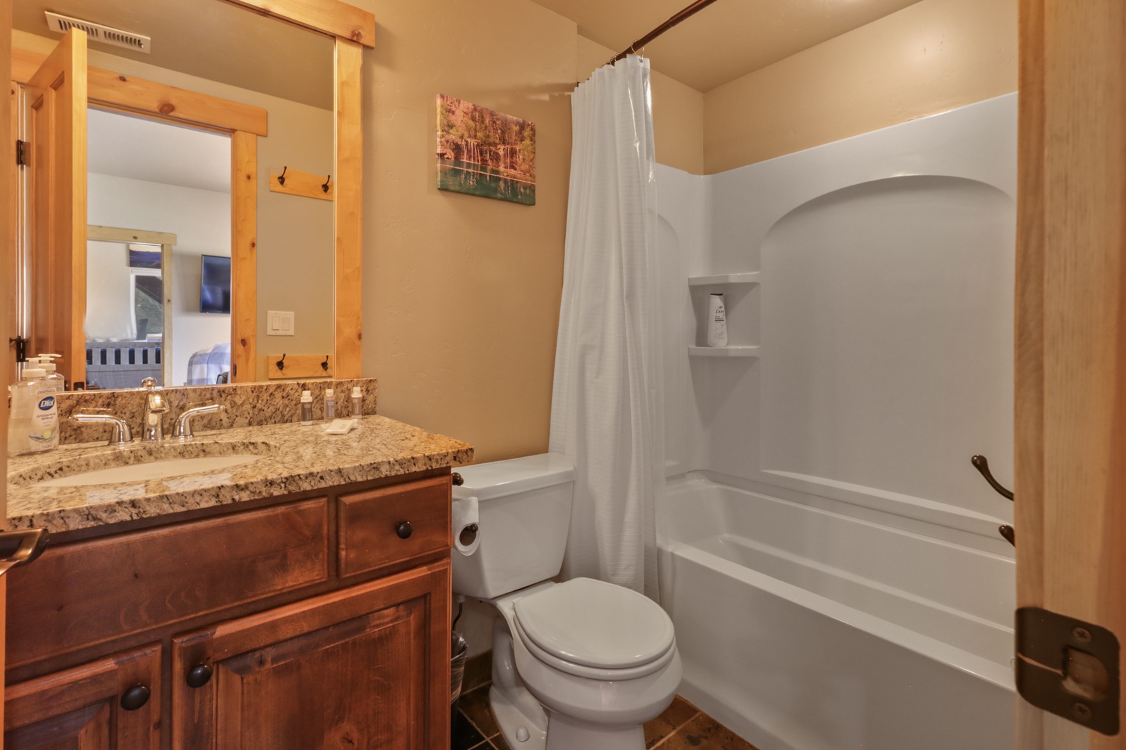 Freshen up in your private bathroom with a spacious tub-shower combo, granite double vanity, and thoughtful touches like soap and grab bars for added comfort.