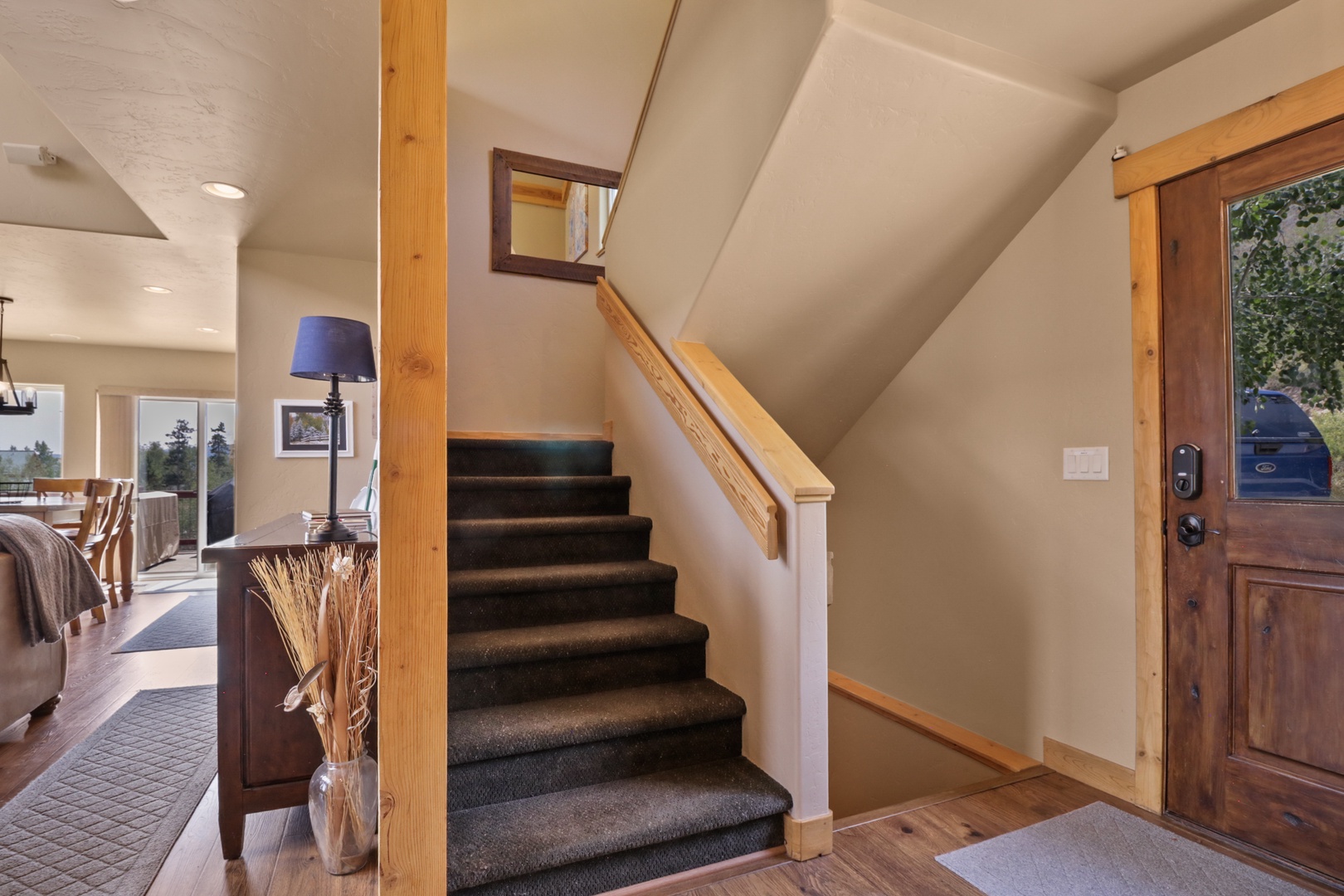 Step into a welcoming entryway where warm wood accents and natural light invite you upstairs. The thoughtful layout seamlessly connects living spaces, making this rental feel like your own mountain retreat.