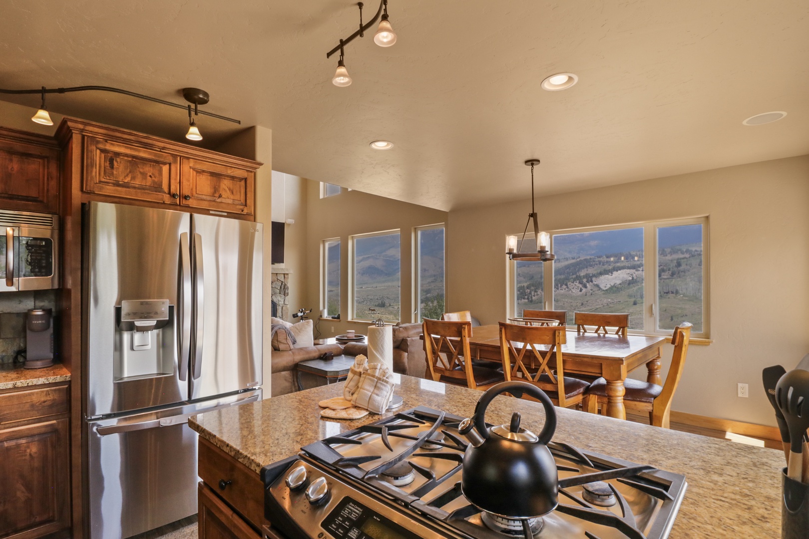 Your open kitchen flows seamlessly into the dining and living areas, where mountain vistas through expansive windows turn every meal into a scenic experience.