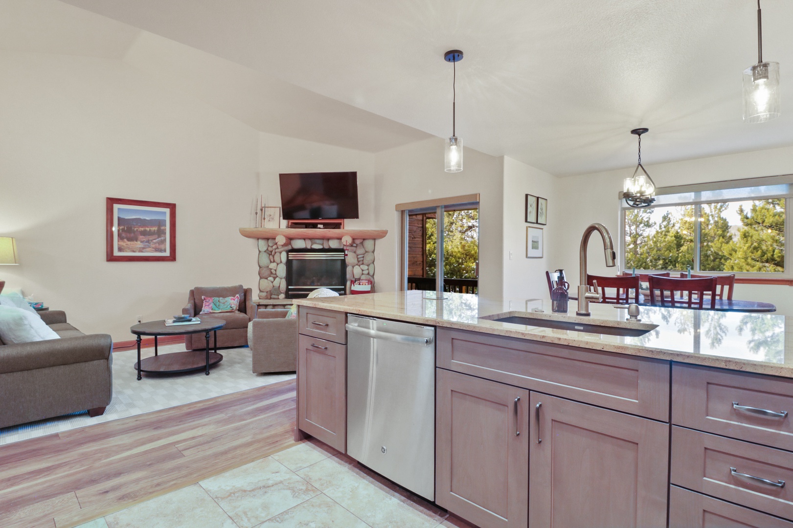 Cook, dine and relax in this bright open-plan space where your kitchen island flows seamlessly into the cozy living area with fireplace and tree views.