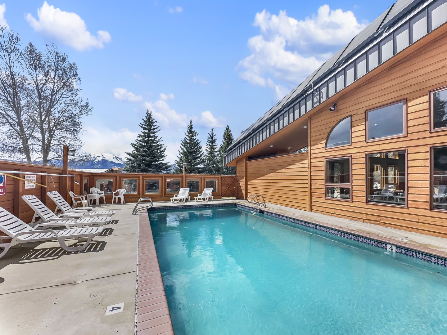Outdoor pool area surrounded by mountain views and natural wood architecture creates perfect relaxation space.