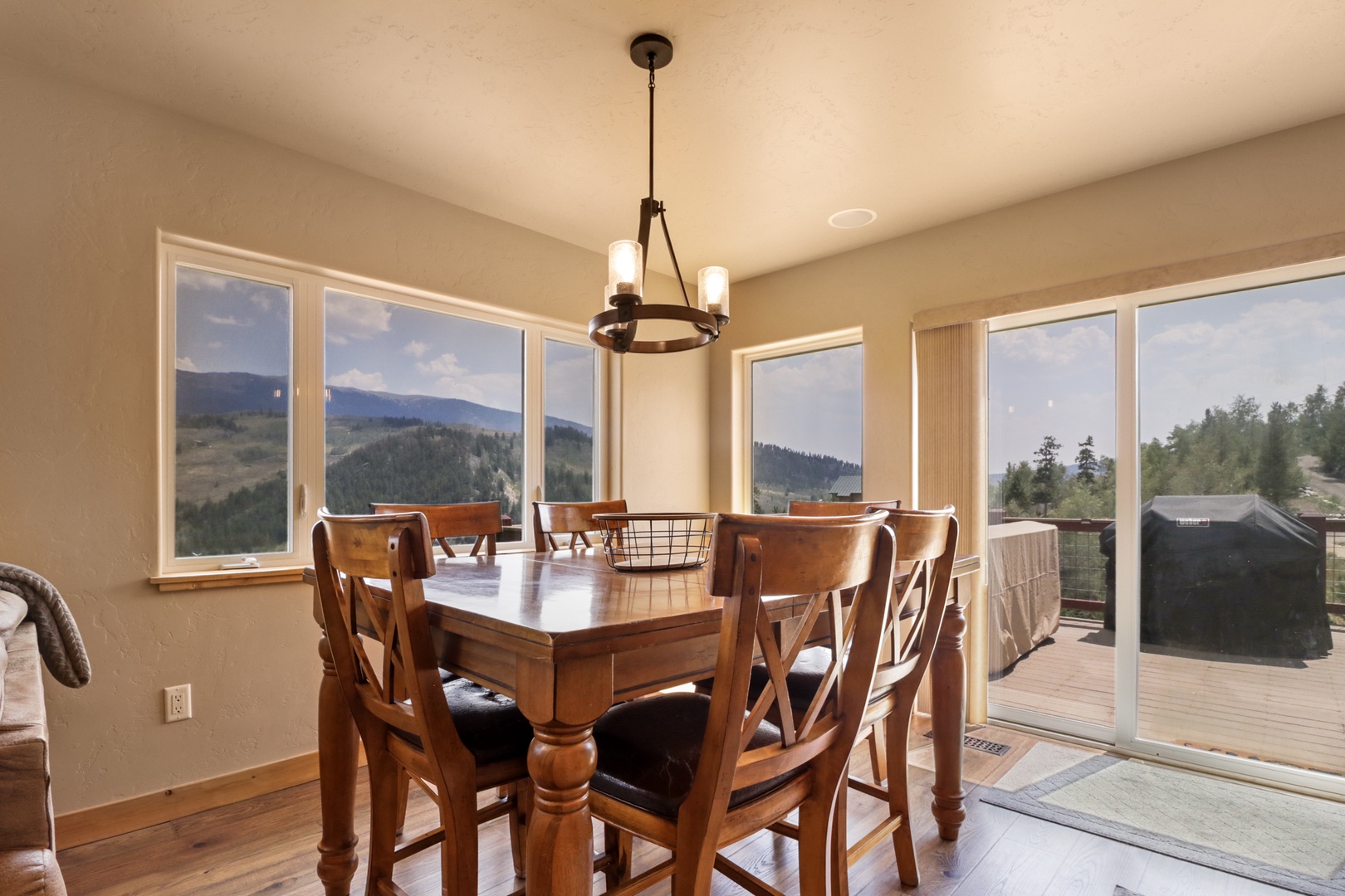 Gather around this warm dining table and soak in the sweeping mountain views through expansive windows—your meals here come with a stunning natural backdrop.