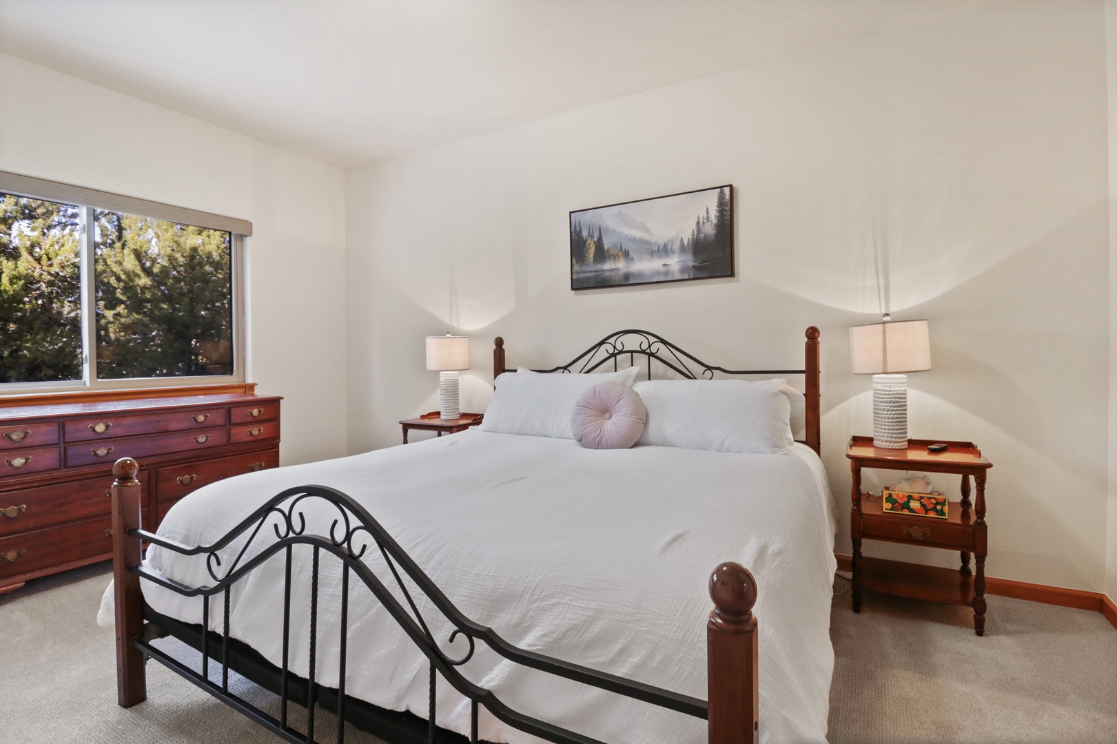 Drift off peacefully in your comfortable bedroom, featuring crisp white linens and warm wooden accents that create the perfect restful retreat.