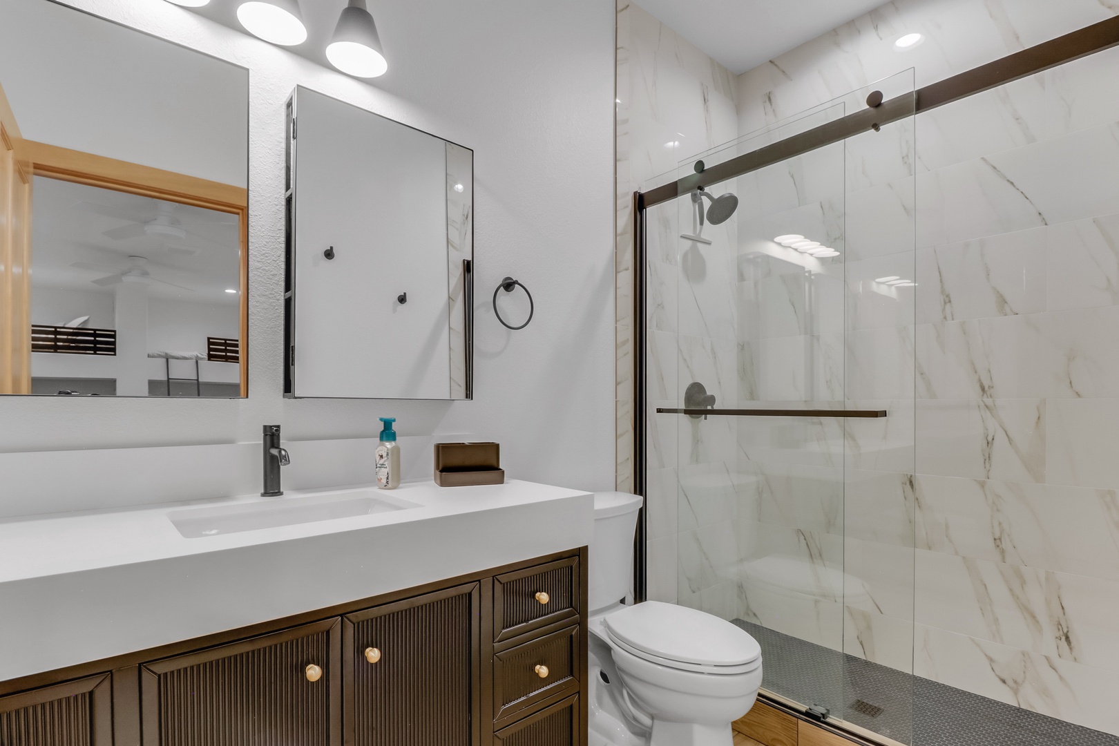 Unwind in your elegant marble bathroom with a spacious walk-in shower and modern vanity—the perfect retreat after exploring.