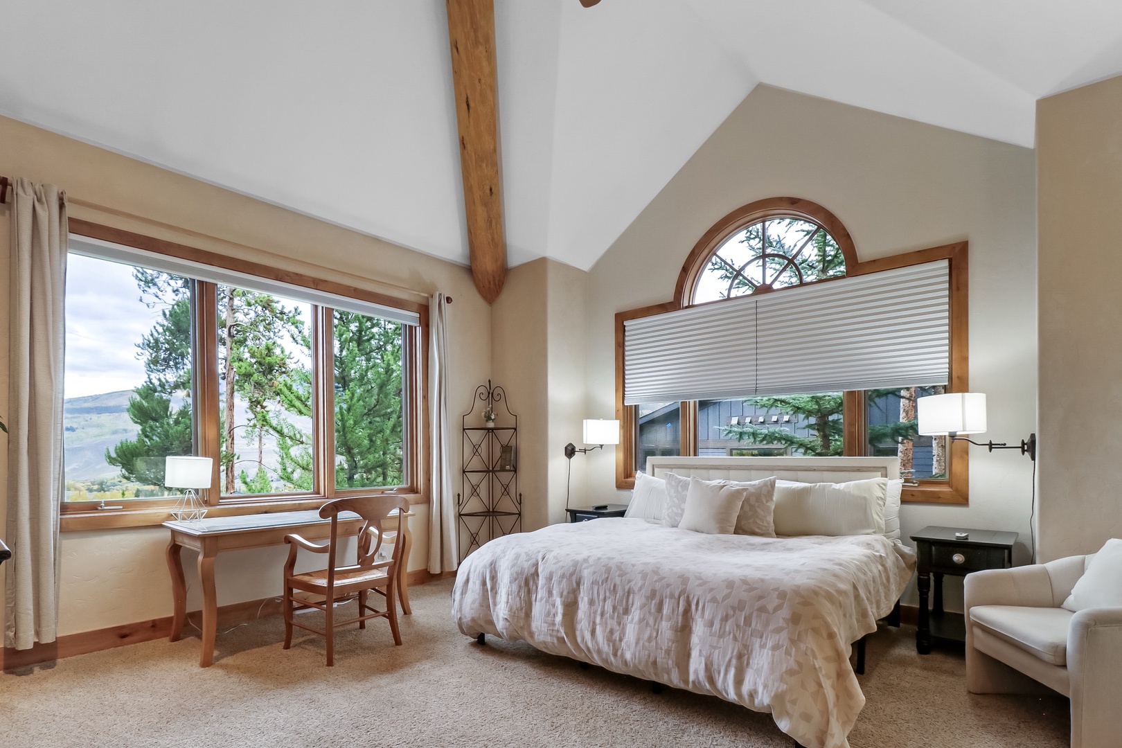Your bright and airy bedroom features soaring vaulted ceilings, elegant wood-framed windows that fill the space with natural light, and a cozy workspace where you can start your mornings peacefully.
