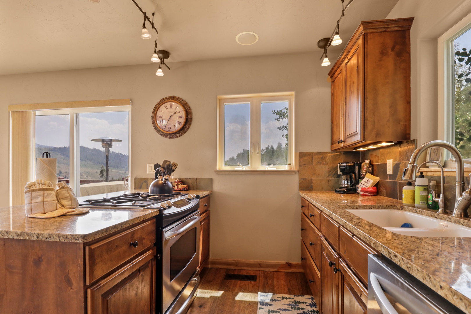Step into your fully equipped kitchen with granite counters, rich wood cabinetry, and mountain views framing your morning coffee routine.