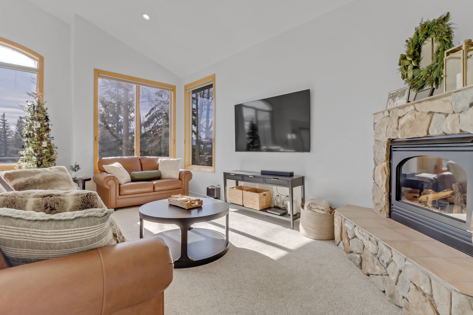 Curl up by your crackling stone fireplace in this cozy living room, where leather seating and mountain views create the perfect retreat.