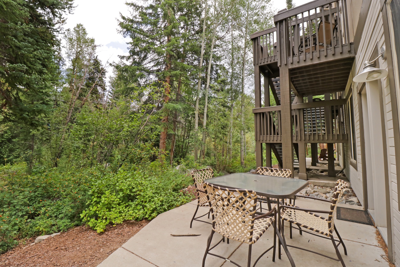 Enjoy your morning coffee on your private patio, surrounded by tall trees and fresh mountain air. The multi-level deck above offers even more space to soak in the peaceful forest setting.