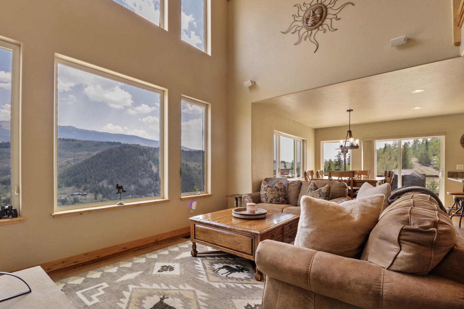 Sink into plush seating and lose yourself in sweeping mountain vistas through soaring windows. The open floor plan connects living and dining spaces, perfect for relaxing after your adventures.