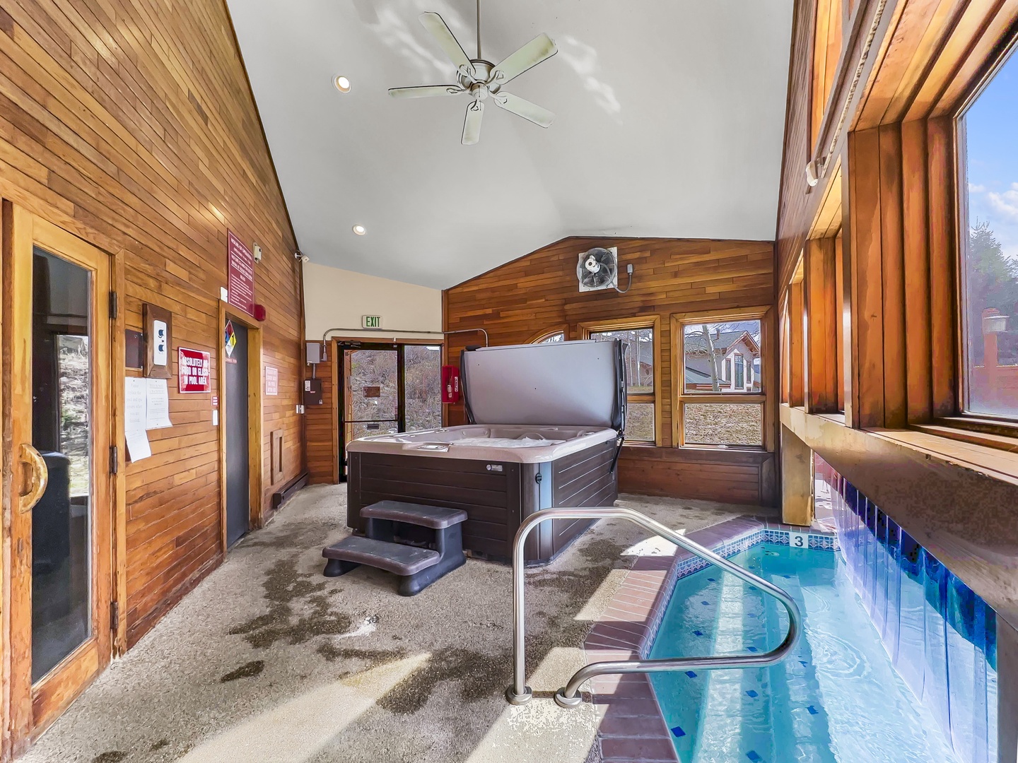 Unwind in your shared wellness sanctuary with a luxurious hot tub and refreshing pool, all within warm wood-paneled walls.