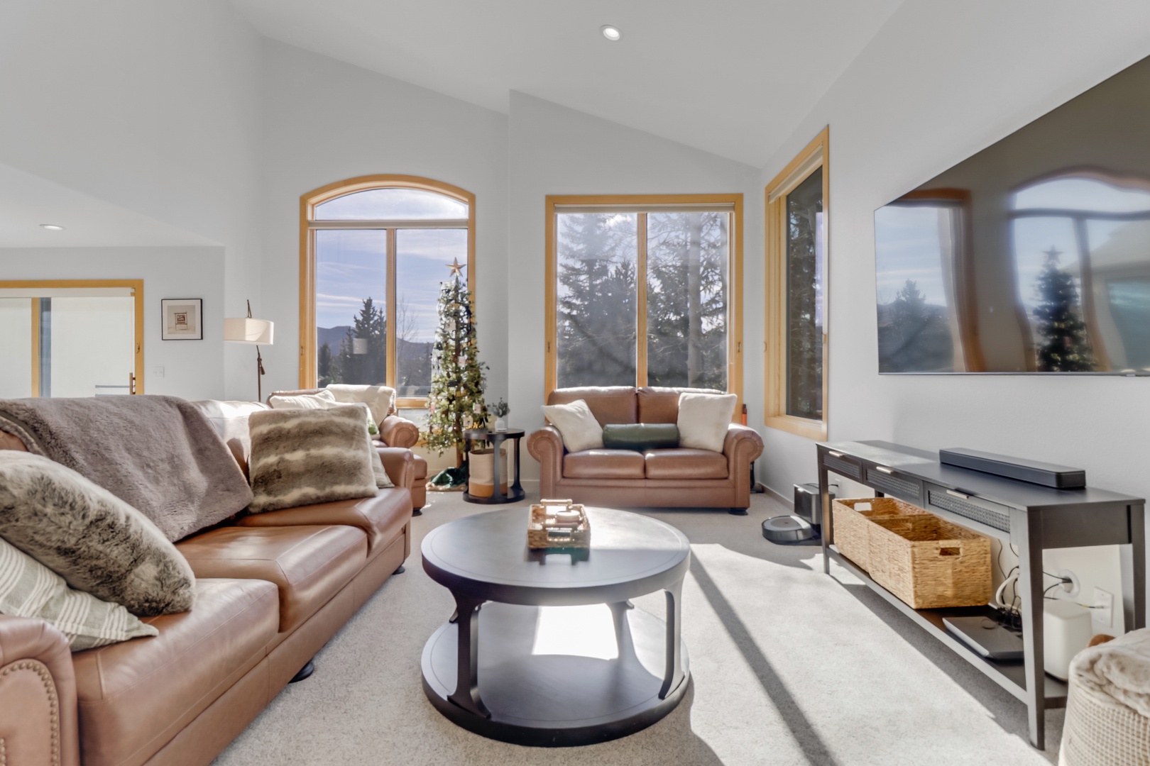 Sink into plush leather sofas while snow-capped mountains frame your perfect winter retreat through expansive windows.