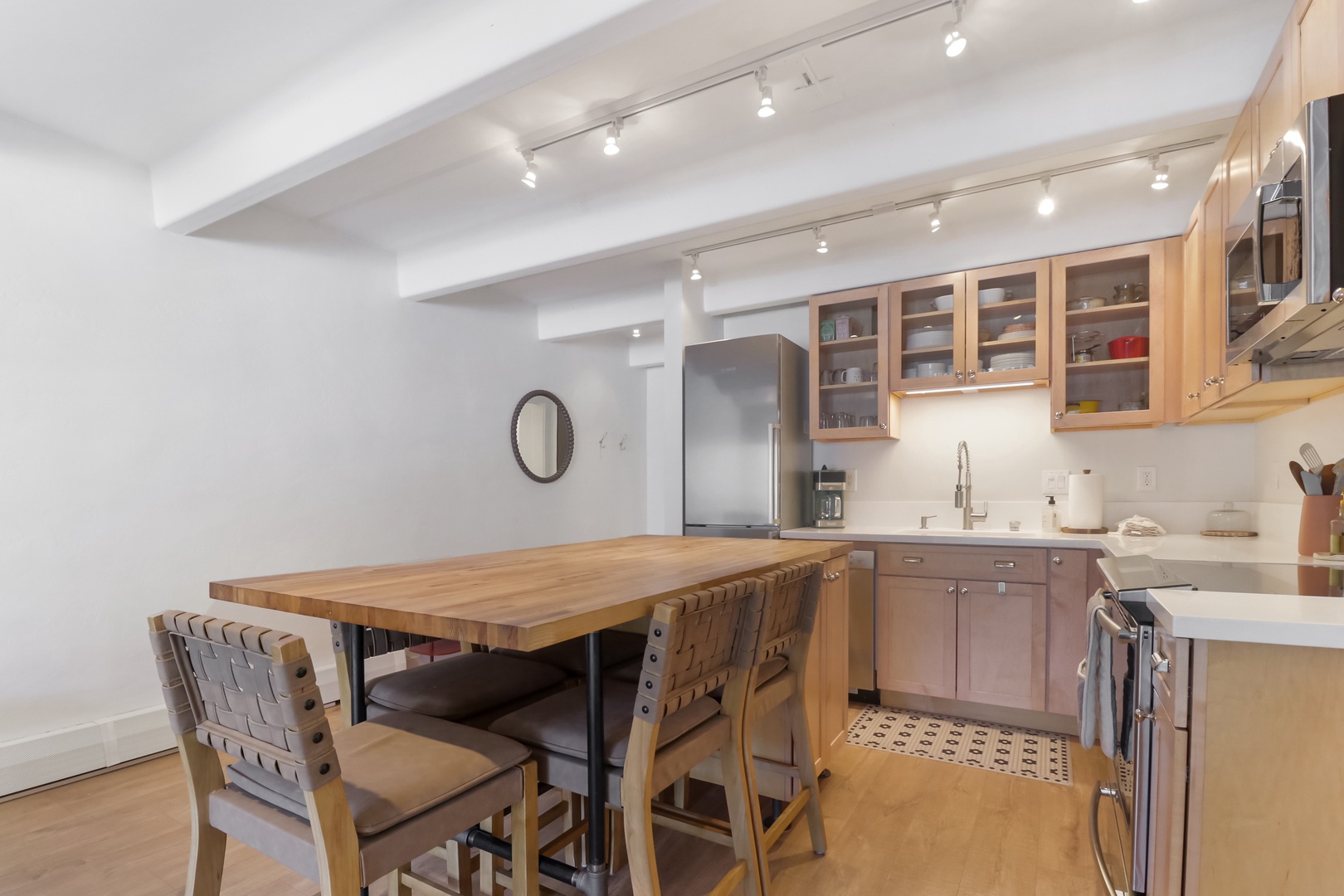 Your fully-equipped kitchen invites culinary adventures with warm wood cabinetry, modern appliances, and a welcoming dining table for memorable meals.