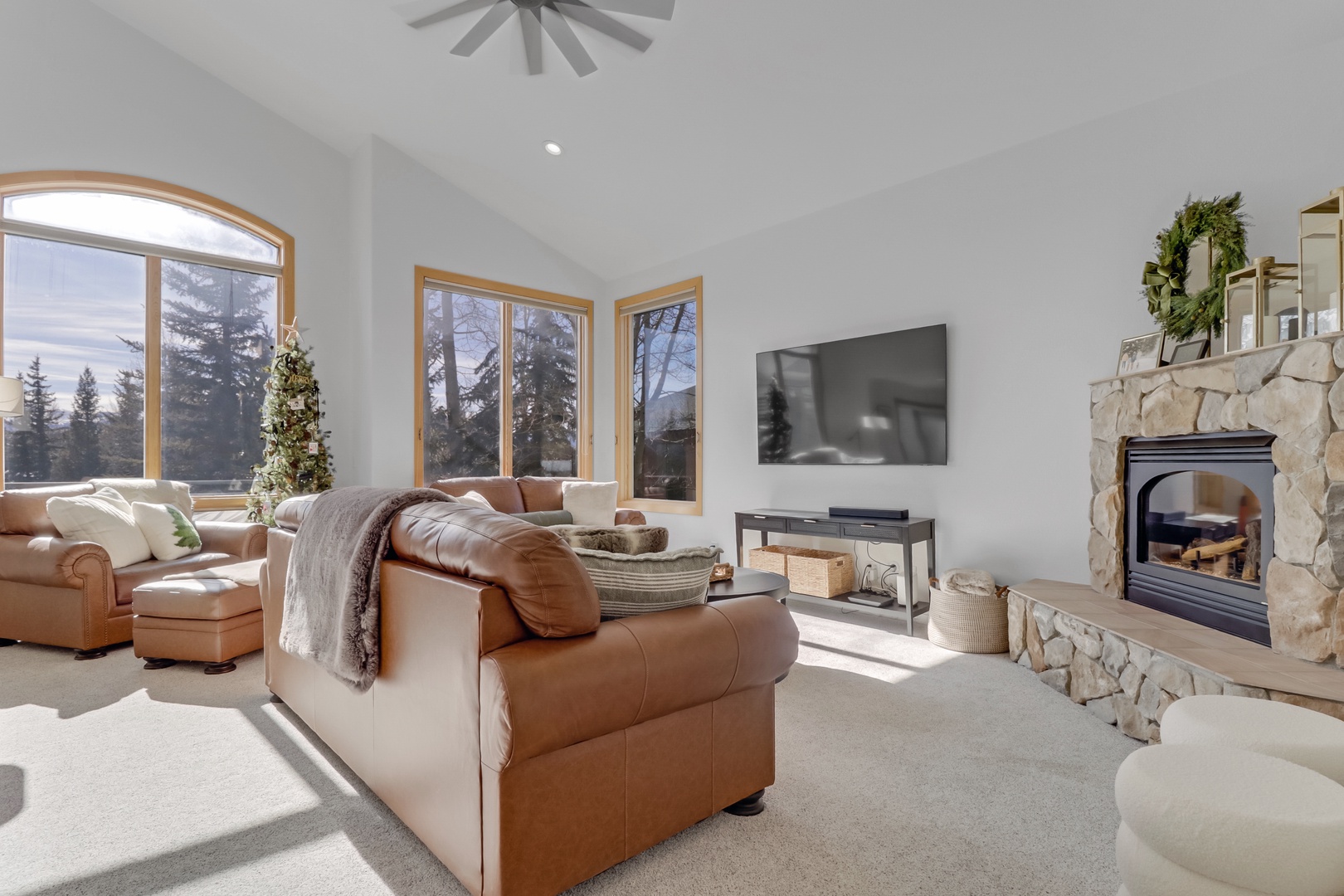 Unwind in your spacious living room where leather sofas invite relaxation by the crackling stone fireplace, while mountain views through windows create perfect moments.