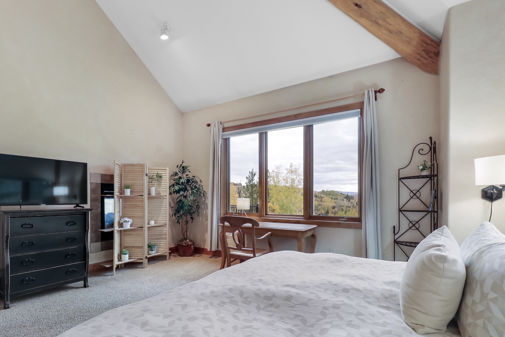 Wake up to peaceful countryside views from your spacious bedroom, where vaulted ceilings with rustic wood beams create an airy retreat. Enjoy morning coffee at the window seat overlooking rolling hills and autumn foliage.