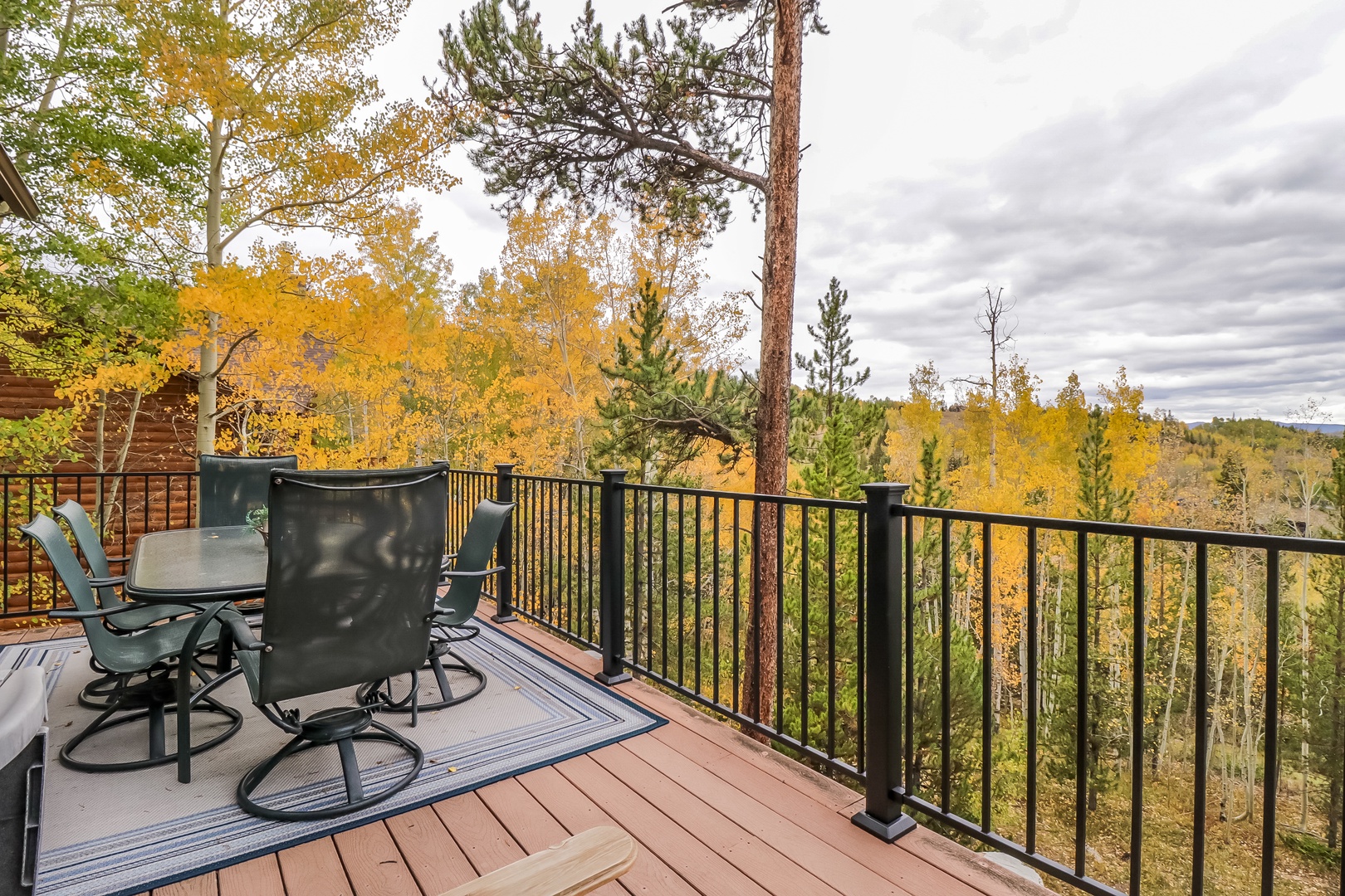 Scenic autumn deck showcasing vibrant fall foliage and a peaceful forested hillside. A quiet space to take in the changing colors from your private outdoor retreat.