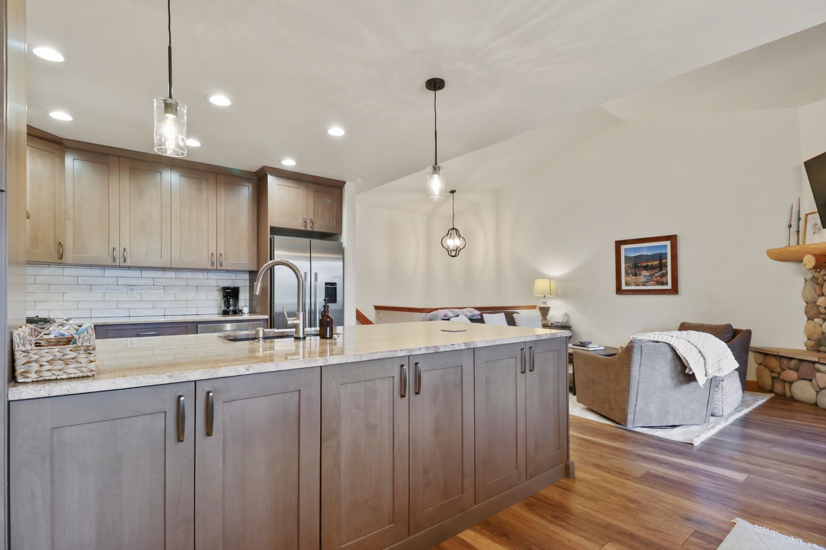 Your open-concept kitchen features granite countertops, stainless steel appliances, and flows seamlessly into the cozy living area with warm wood floors.