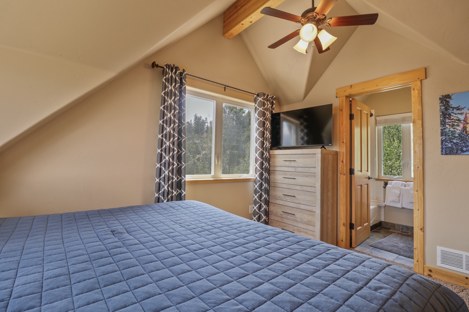 Your peaceful retreat awaits with vaulted ceilings, warm wood accents, and forest views framing the windows—a cozy sanctuary to unwind after exploring the great outdoors.