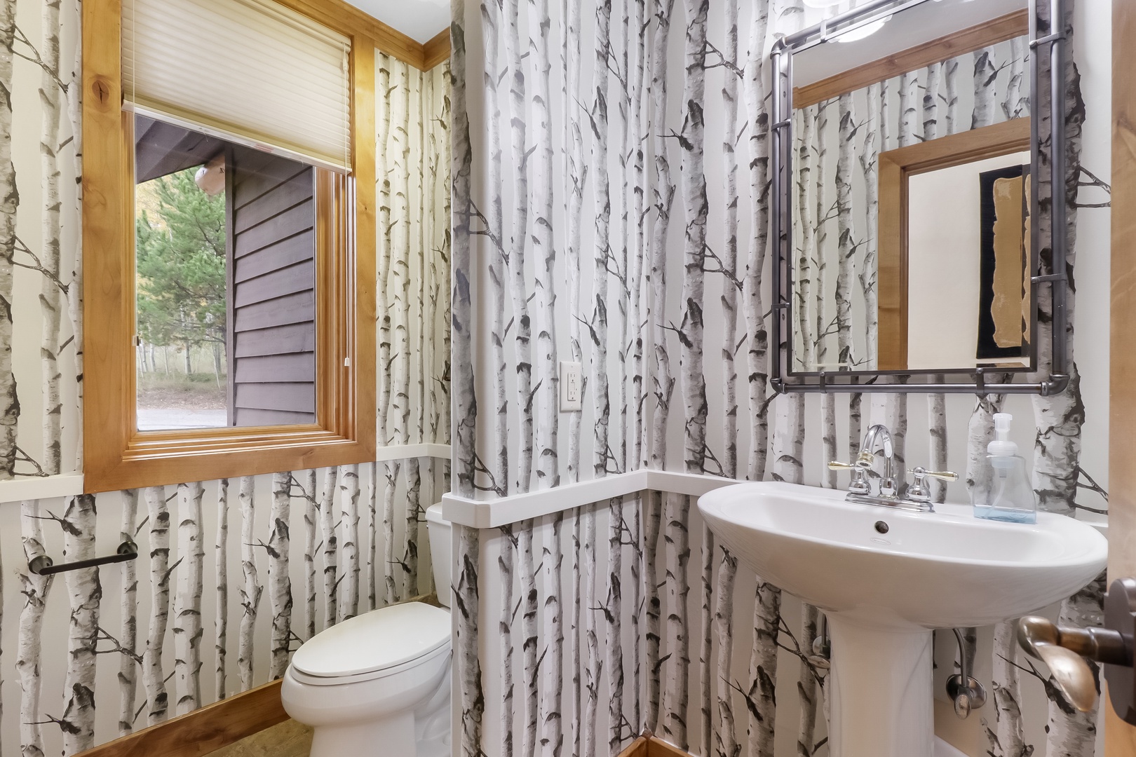 Freshen up in your private bathroom, where birch-inspired walls and natural light create a serene woodland retreat after a day of adventure.