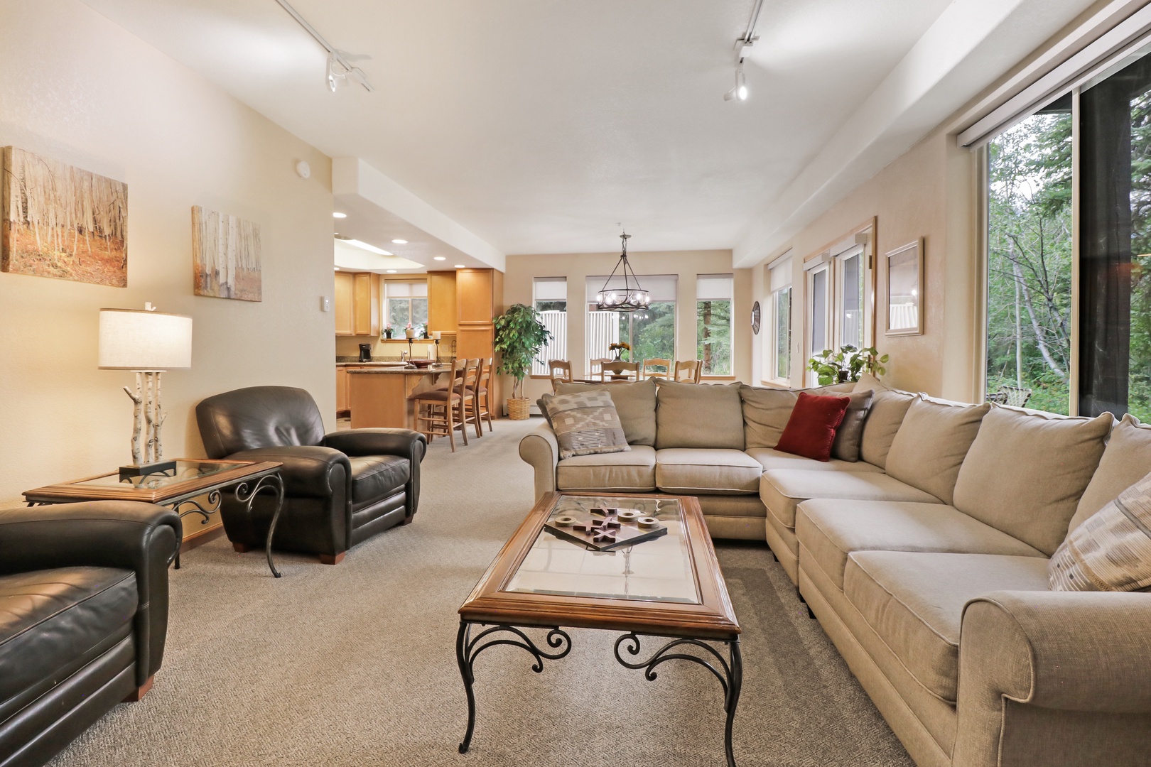 Sink into plush seating and let natural light fill your afternoons in this spacious open-concept retreat, where forest views and modern comfort blend effortlessly.