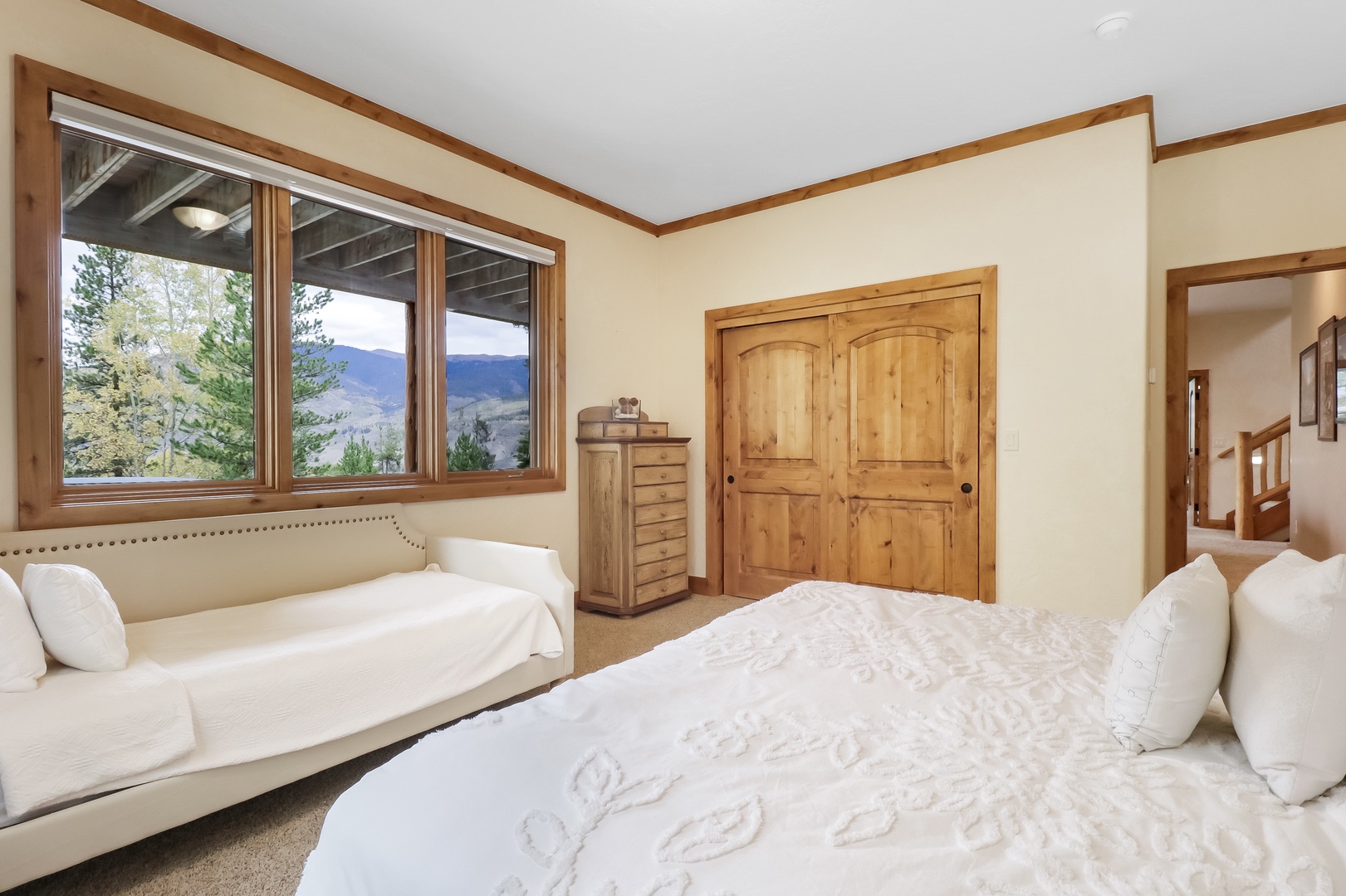 Wake up to stunning mountain views framed by your bedroom window. Crisp linens, natural wood accents, and a cozy daybed invite you to unwind in peaceful serenity.
