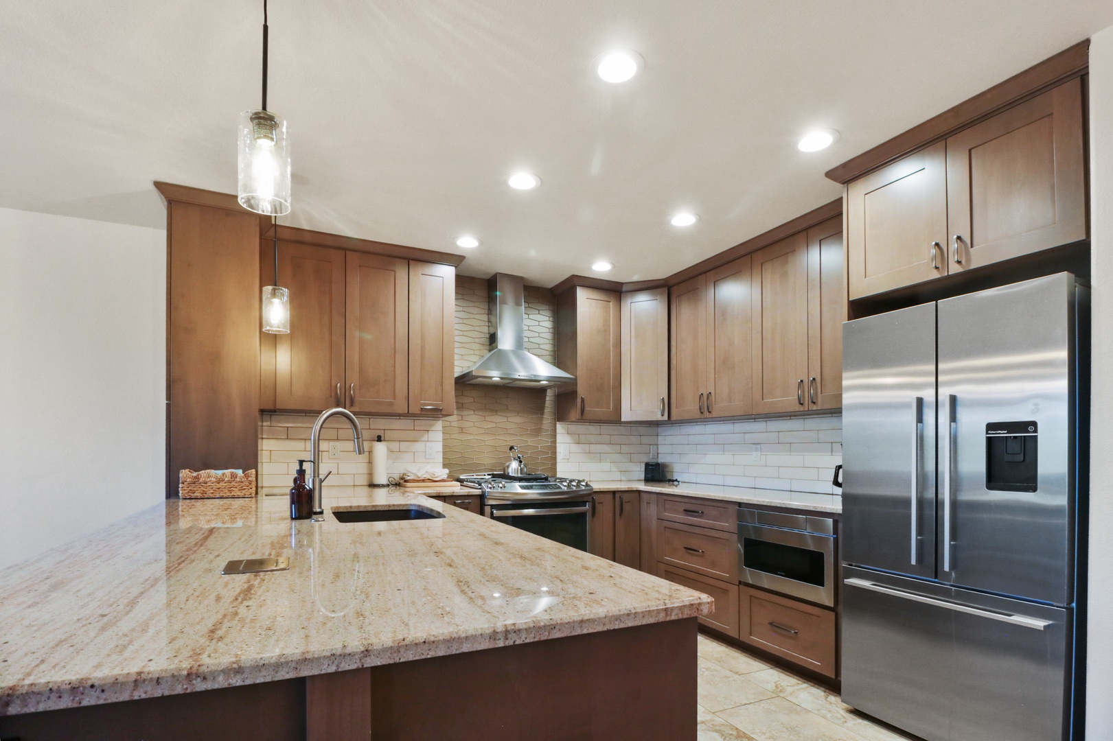 Your fully equipped gourmet kitchen awaits with granite counters, stainless appliances, and warm wood cabinets for memorable meal preparation.
