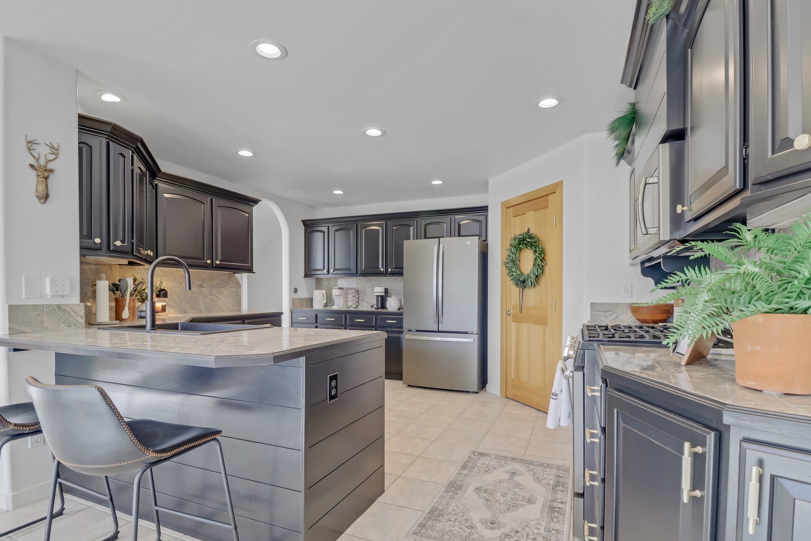 Cook your favorite meals in this elegant kitchen featuring granite countertops, stainless steel appliances, and a convenient breakfast bar.