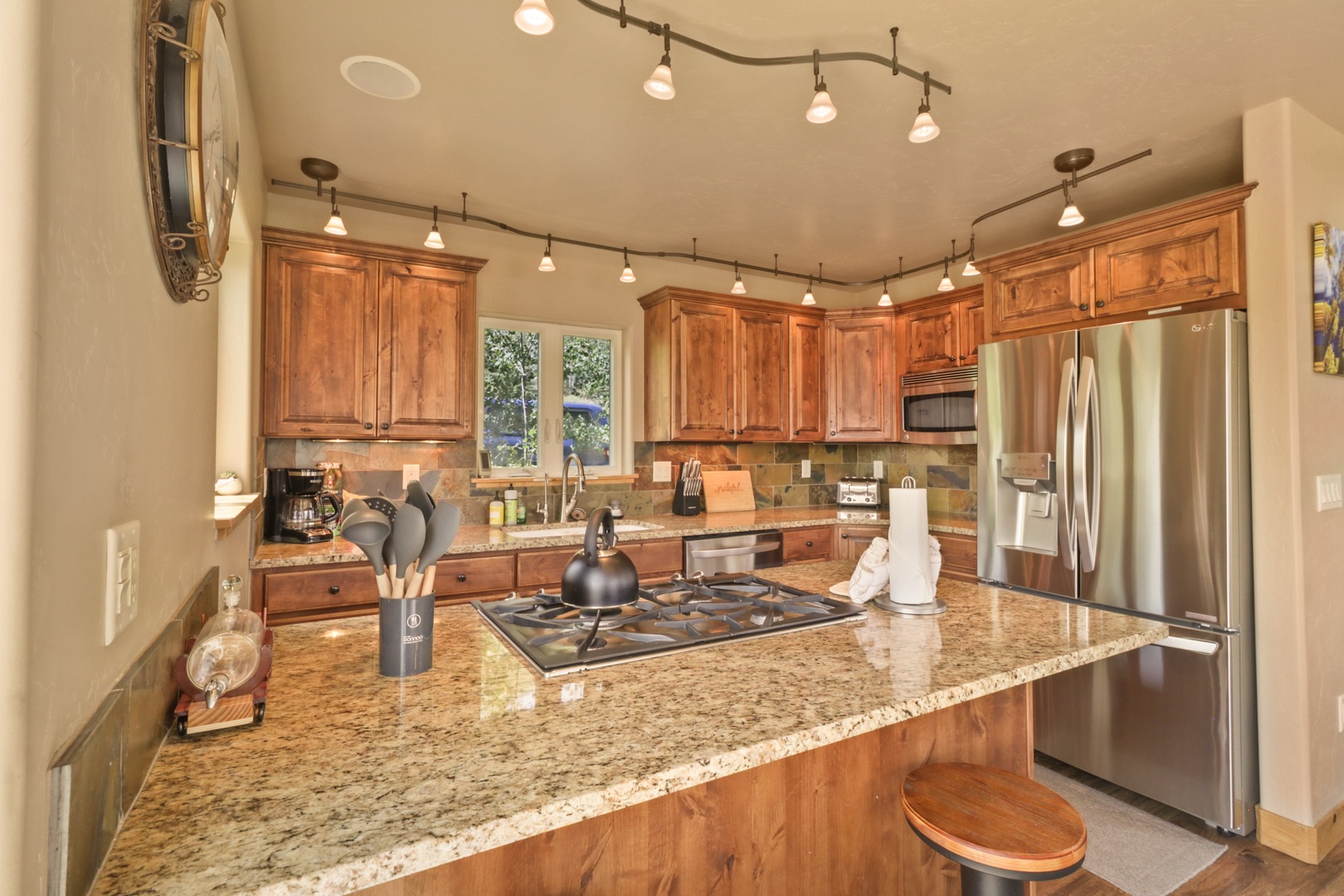 Step into a gourmet kitchen where warm wood cabinetry and gleaming granite countertops invite you to whip up your favorite meals. Natural light pours in, and the spacious island becomes your gathering spot for morning coffee or evening wine.