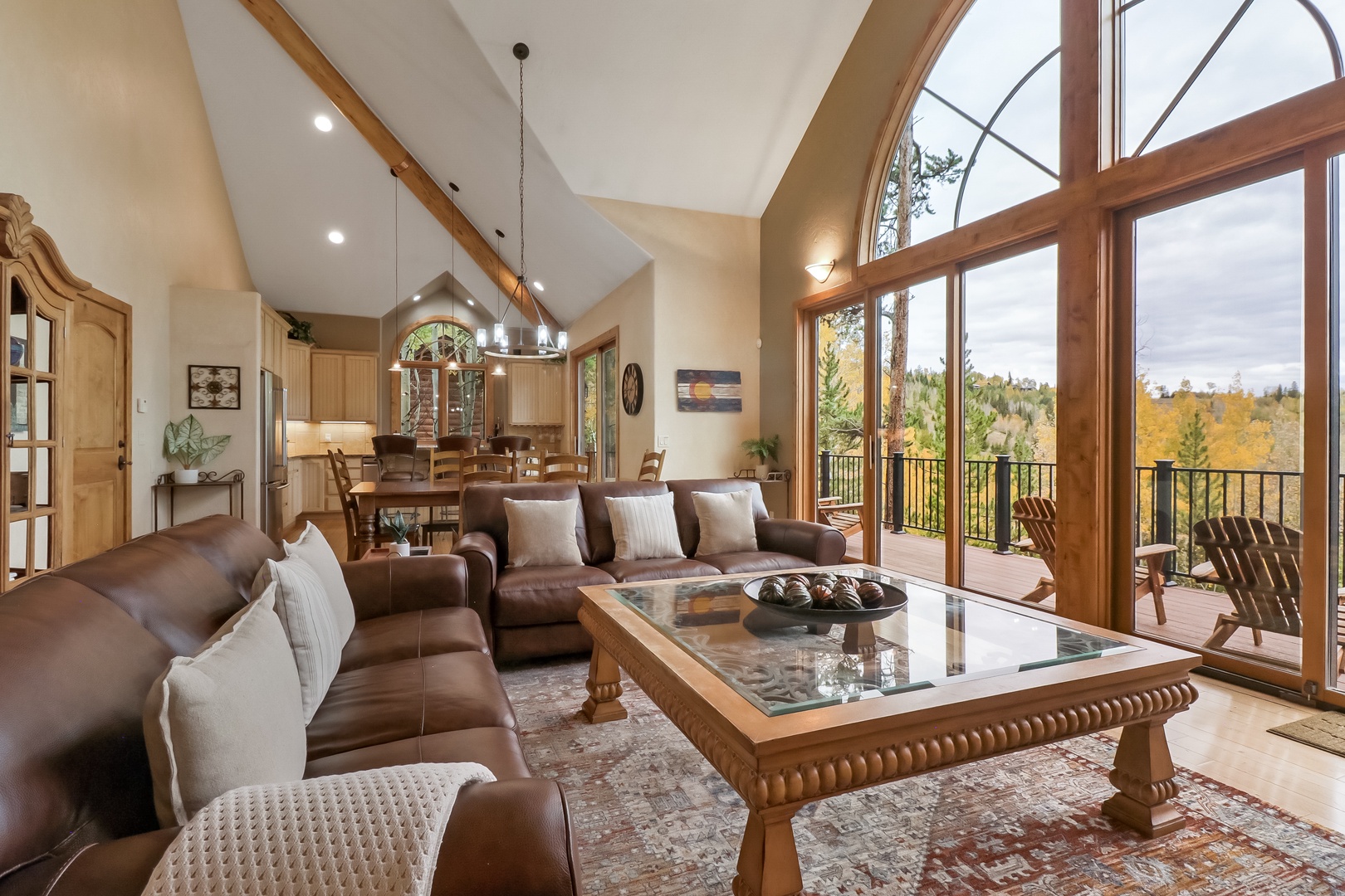 Step into your spacious living area where vaulted ceilings and stunning windows frame sweeping fall foliage views. Relax on the leather sofas or step onto your private balcony to soak in the peaceful scenery.