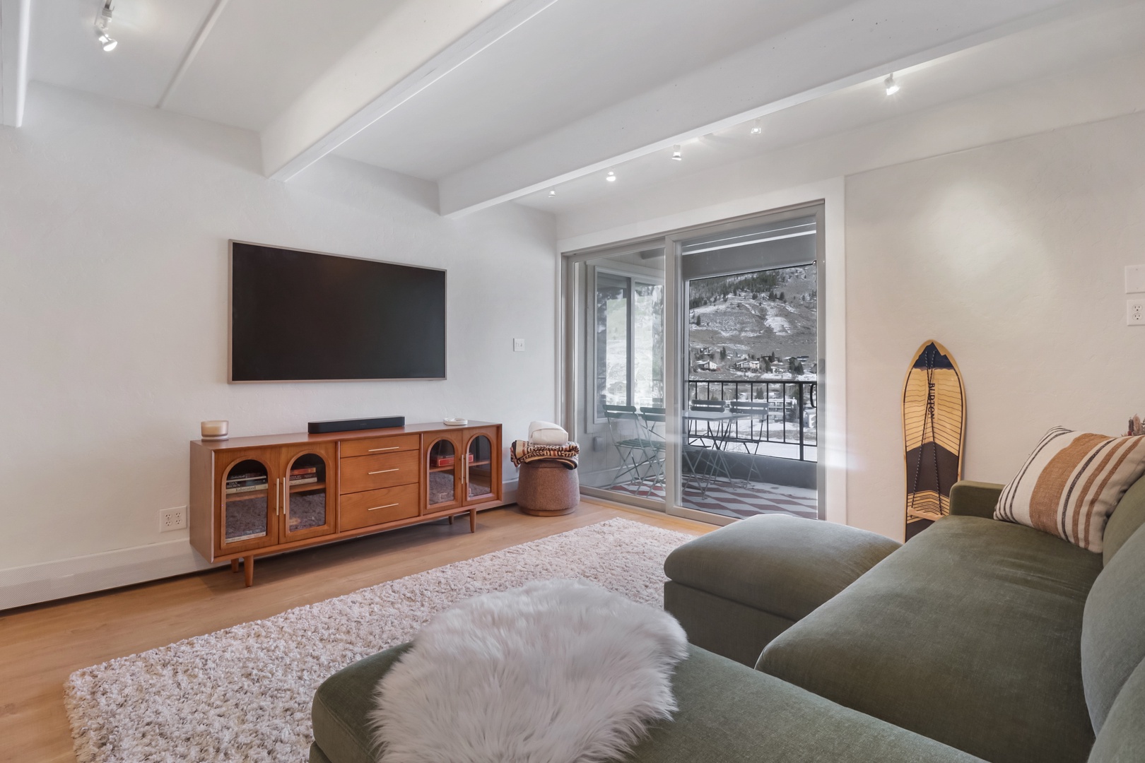 Sink into plush seating in your bright, modern living space with exposed beams and mountain views from your private balcony.