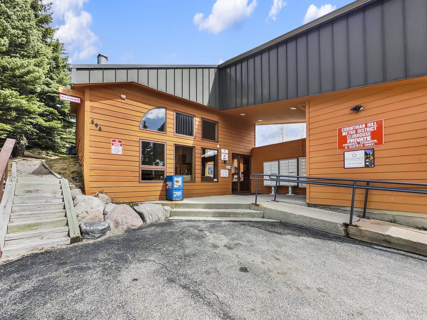 Modern mountain lodge entrance featuring warm wood siding and contemporary design elements in a scenic alpine setting.
