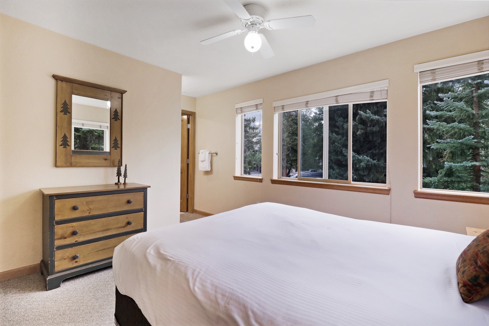 Wake up to views of towering pines framing your windows, while the ceiling fan keeps your space perfectly comfortable. The rustic charm of the wood-accented furniture adds a cozy mountain lodge feel to your restful retreat.