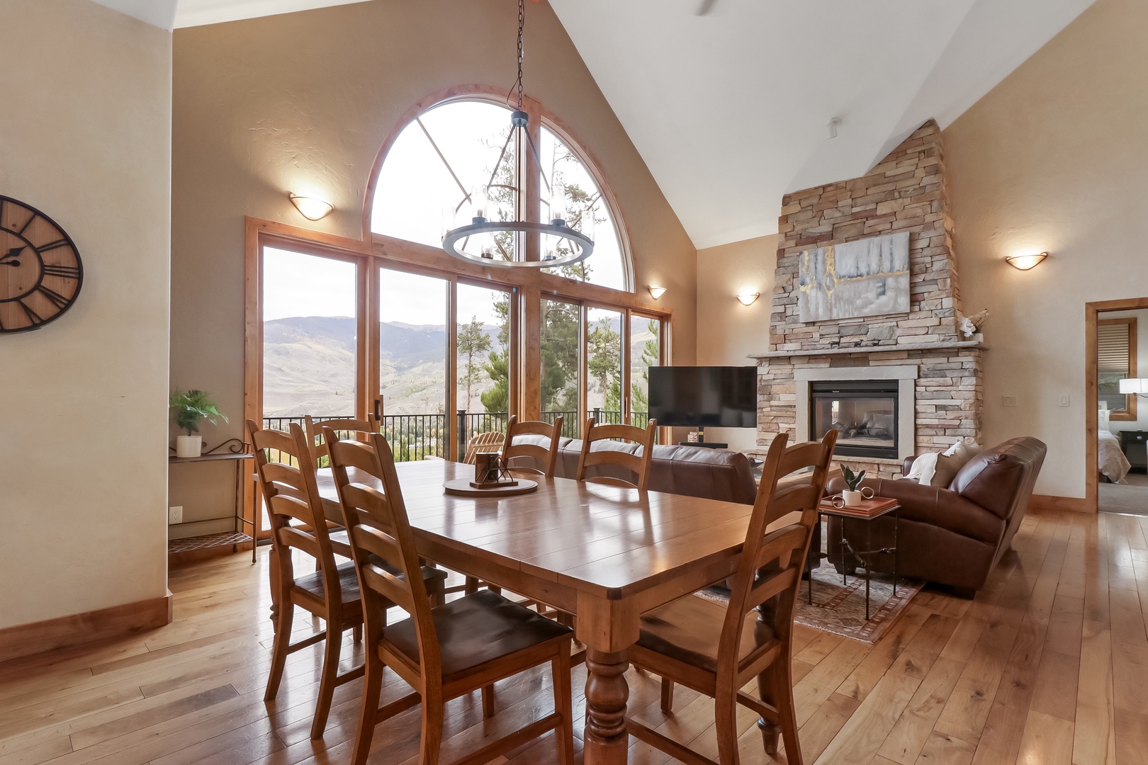 Gather around the handcrafted dining table and soak in sweeping mountain views through soaring windows. With a cozy stone fireplace and open flow to the living area, this space sets the stage for memorable meals together.