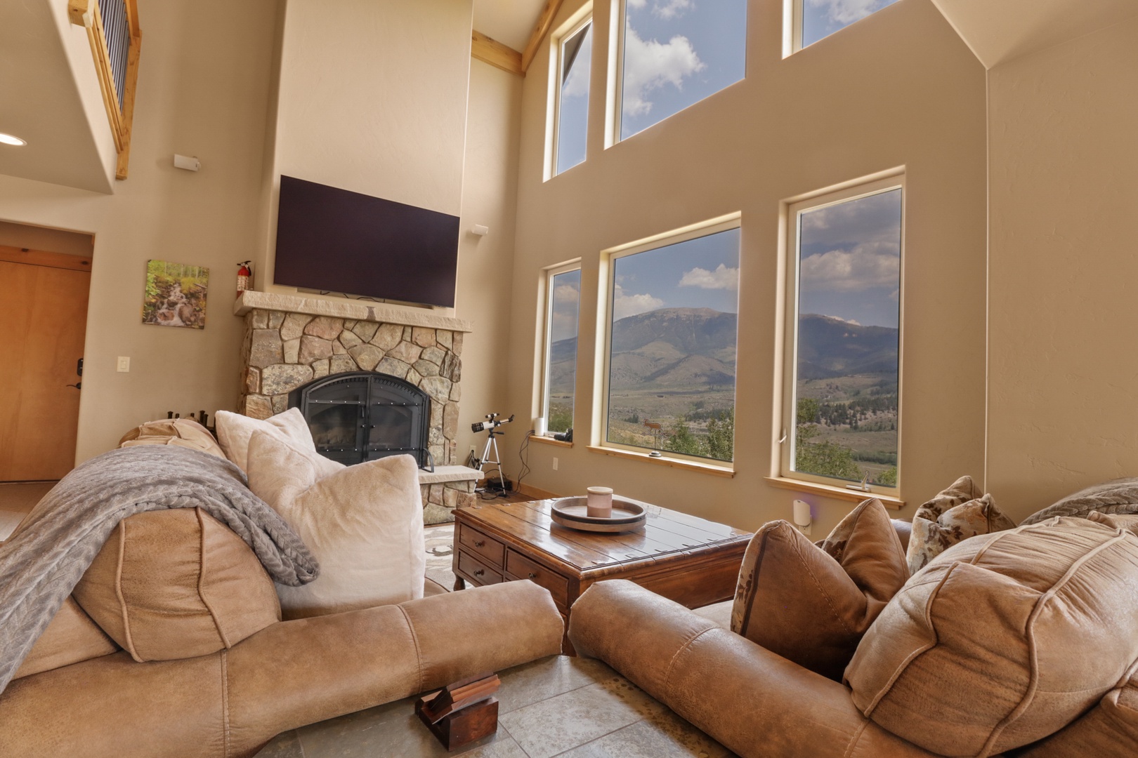 Sink into comfy seating beside the warmth of your own fireplace as you soak in sweeping mountain vistas through soaring windows—your perfect retreat for both relaxation and inspiration.