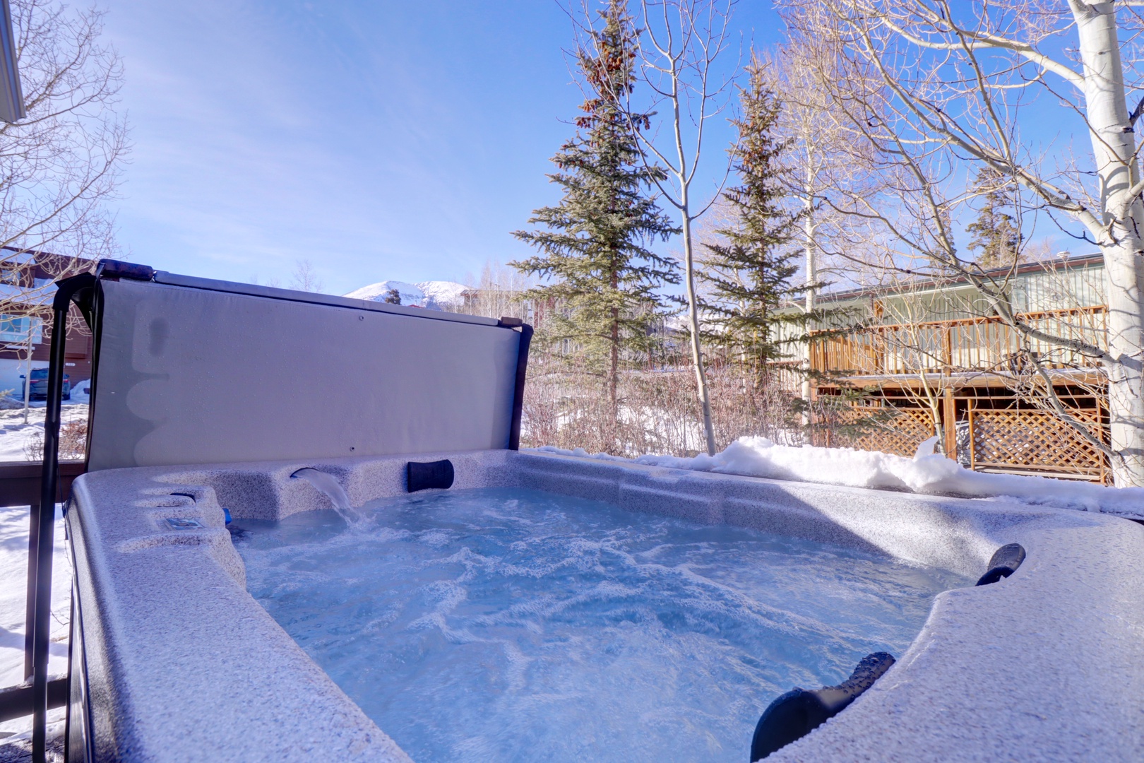 Soak in the bubbling warmth of your private hot tub while surrounded by snow-covered trees and crisp winter air - the perfect mountain retreat experience.