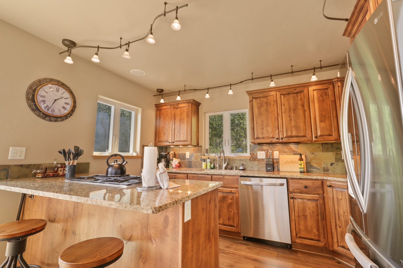 Step into your fully equipped kitchen, where gleaming granite counters and warm wood cabinets invite you to cook your favorite meals. Bright natural light pours through the windows as you gather around the breakfast bar with morning coffee in hand.