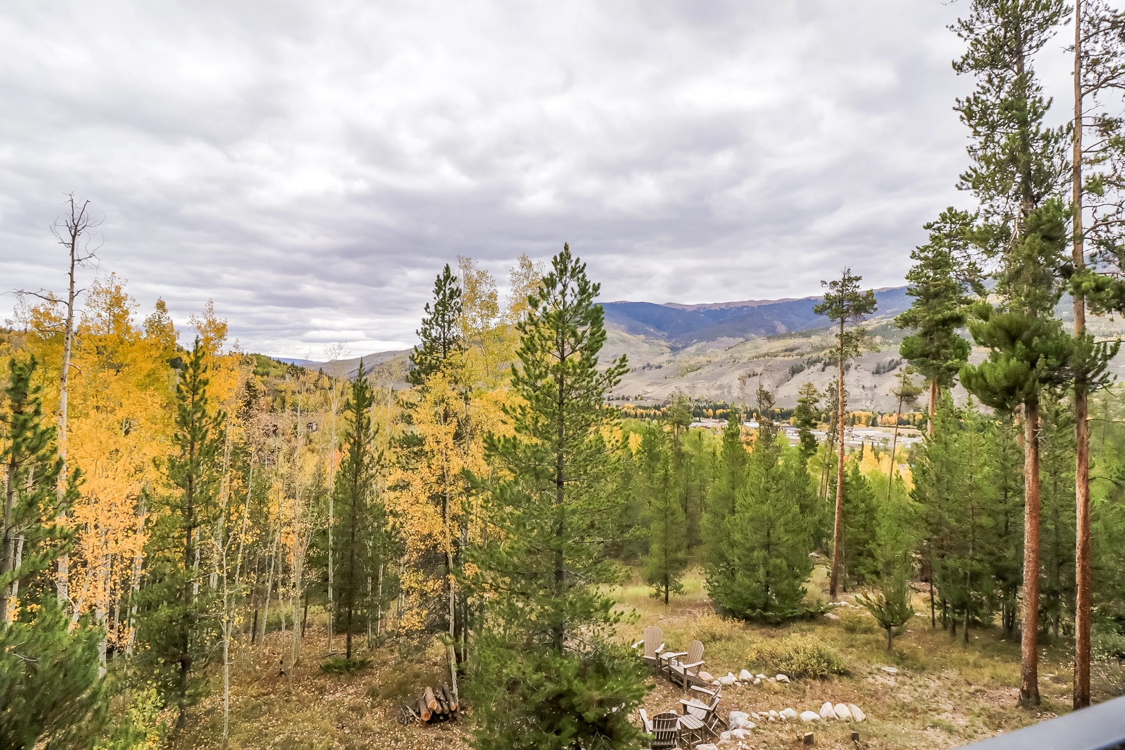 Mountain scenery with autumn foliage and evergreen forests in the surrounding valley area.