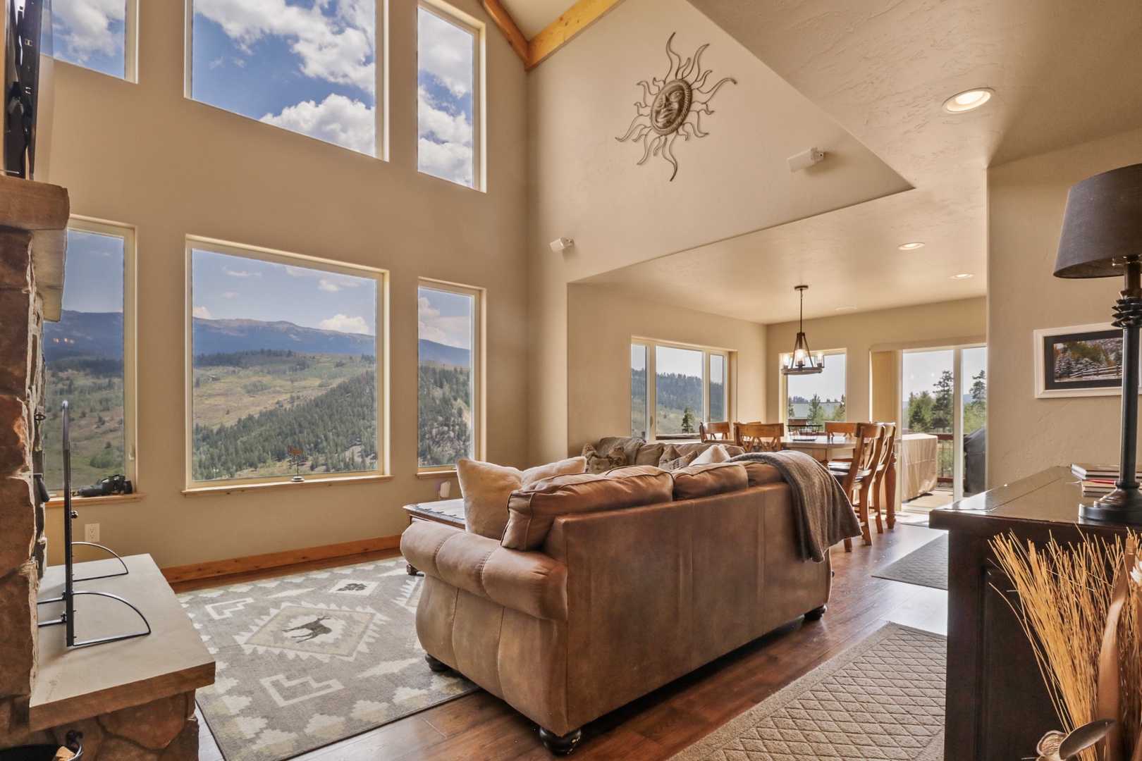 Unwind in your expansive living area where floor-to-ceiling windows frame stunning mountain vistas. Sink into the plush leather sofa and let the natural light fill your retreat.