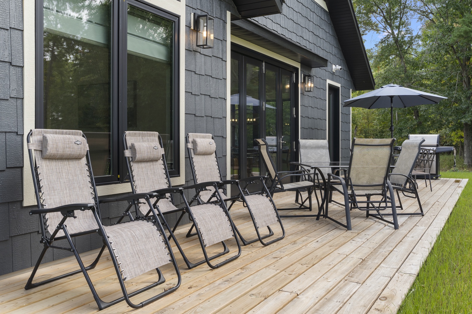 Stretch out and unwind on your private deck, where comfortable loungers and dining seating await beneath the shade of trees. The spacious outdoor space invites you to enjoy morning coffee or evening sunsets in peaceful natural surroundings.