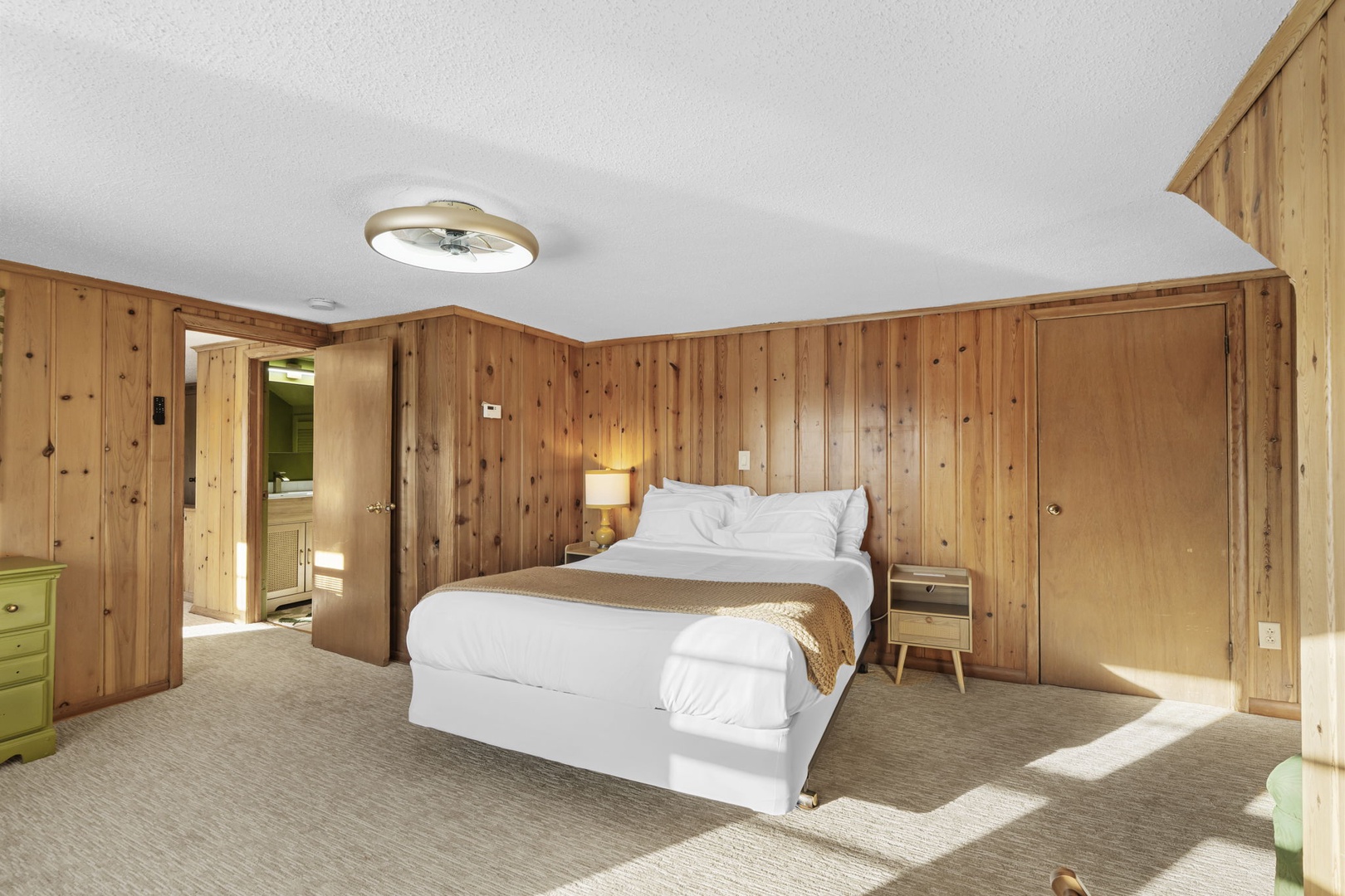 Drift into peaceful slumber in this upstairs bedroom, where warm wood walls and crisp white linens create a cozy retreat.