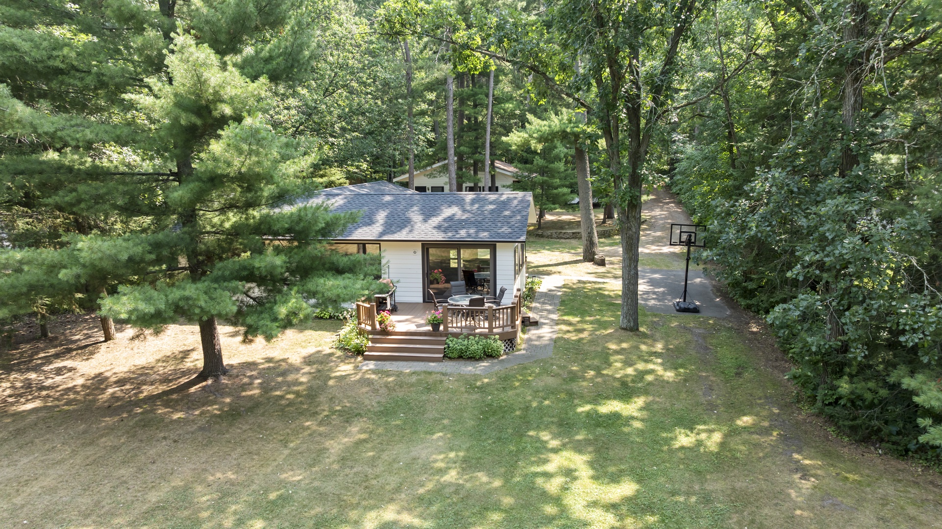 Nestled among towering pines and shaded by lush canopy, this charming retreat offers a private woodland escape with inviting outdoor spaces to unwind.