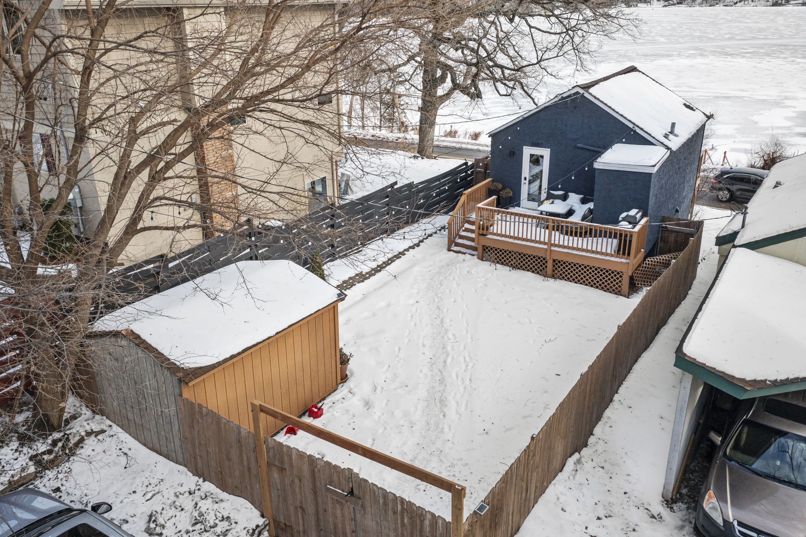 Charming winter retreat with snow-covered deck and private yard, perfect for a peaceful seasonal getaway.