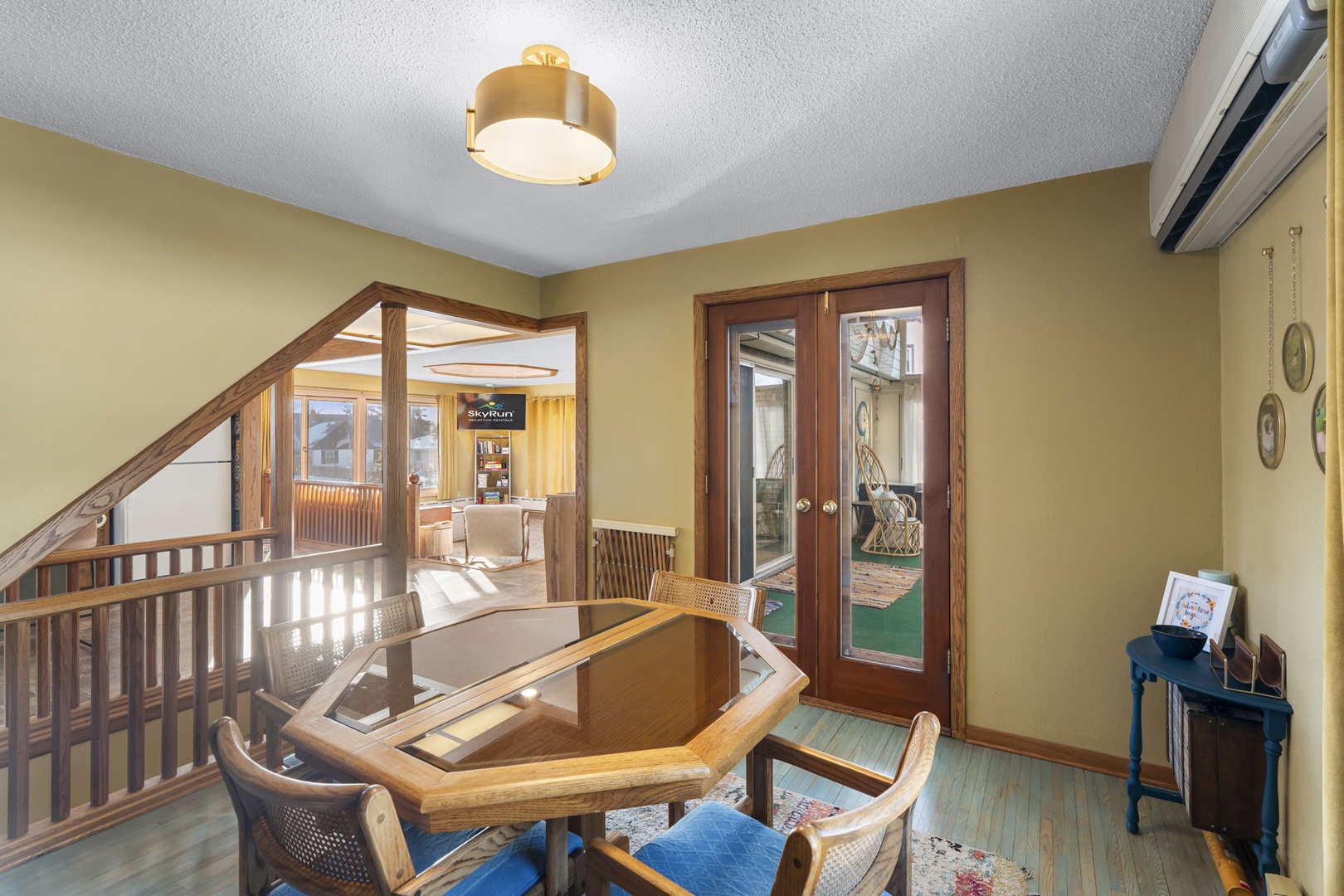 Your main floor dining area or game nook awaits with polished wood table for cards or board games, opening to peaceful outdoor spaces.