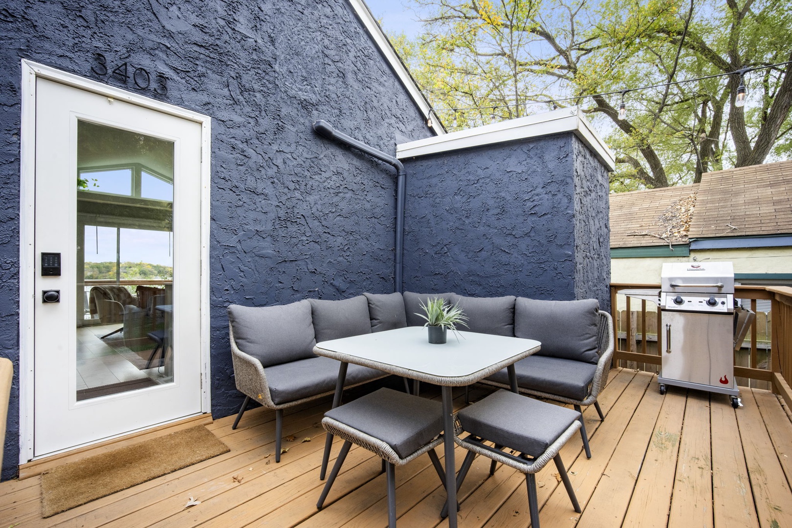 Step out onto your private deck where a cozy outdoor lounge and dining setup awaits—perfect for morning coffee or evening meals under the open sky. A stainless-steel grill stands ready for your cookouts.