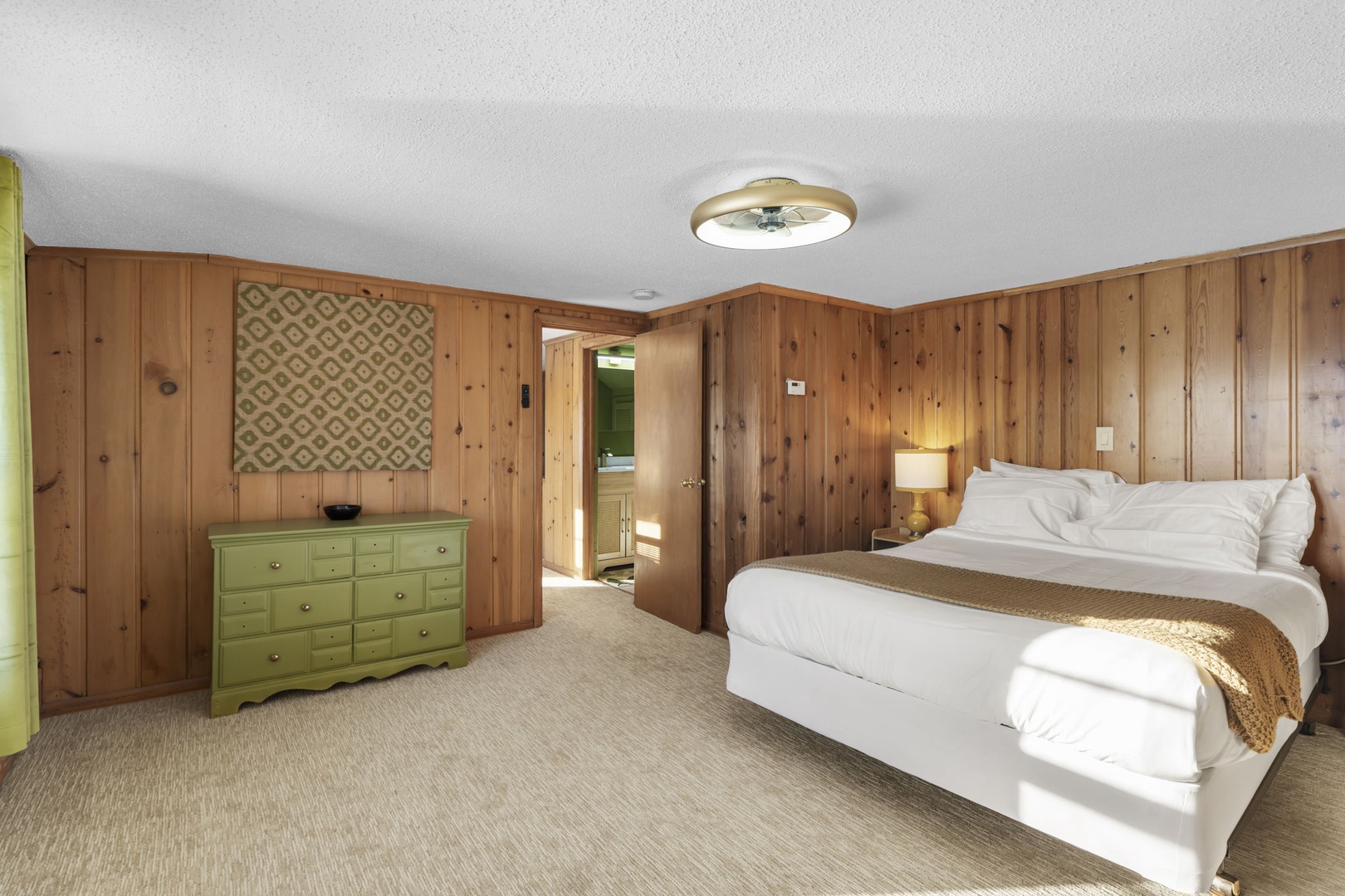 Unwind in your cozy bedroom featuring warm wood paneling and thoughtful touches that create a peaceful retreat.