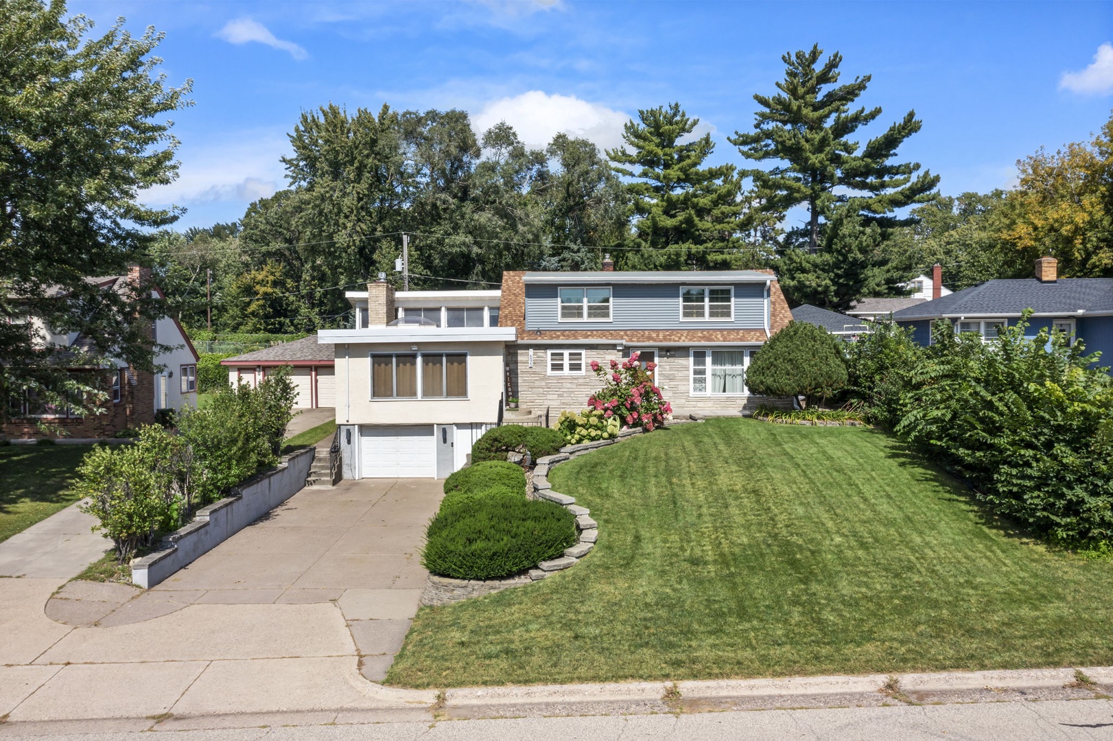 Modern property nestled in a leafy residential neighborhood with manicured grounds and mature trees providing natural privacy.