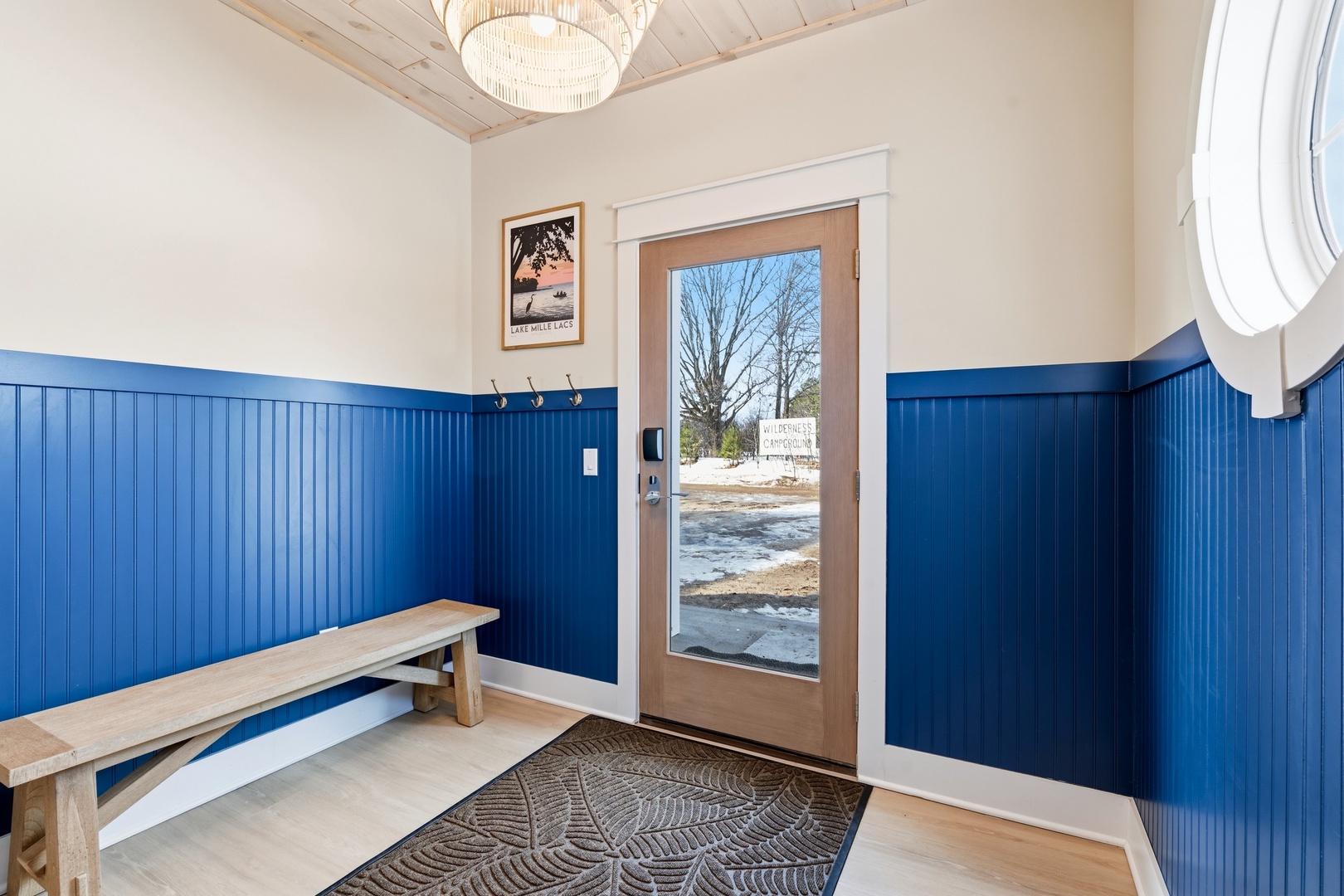 Ground level entryway with blue wainscoting bench and porthole window